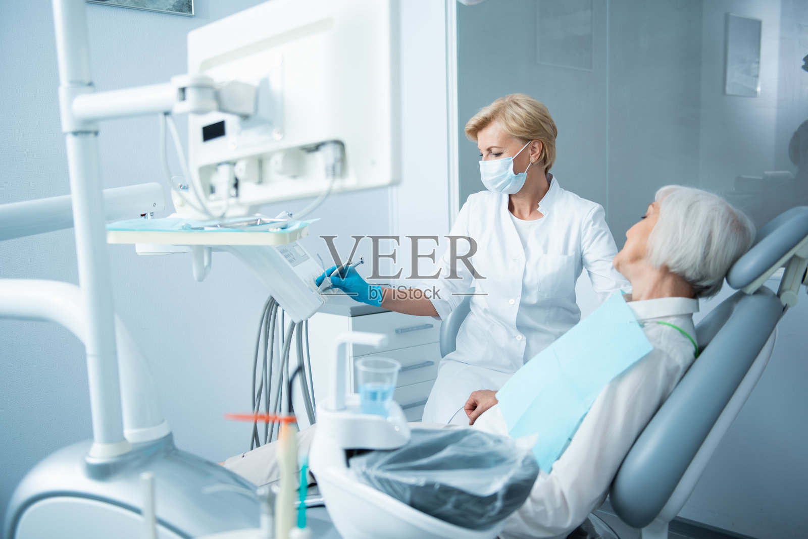 微笑的闭着眼睛的女士躺在牙科椅上照片摄影图片