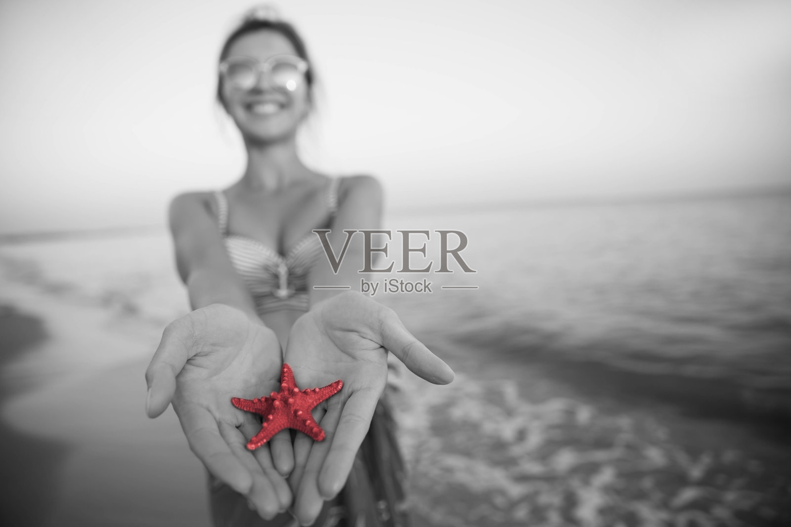 快乐的女人抱着海星照片摄影图片