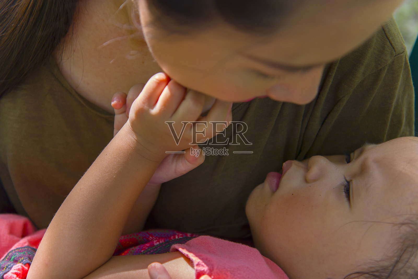 年轻的母亲拥抱和抚慰哭泣的小女儿,亚洲母亲试图安慰和平息她哭泣的孩子照片摄影图片