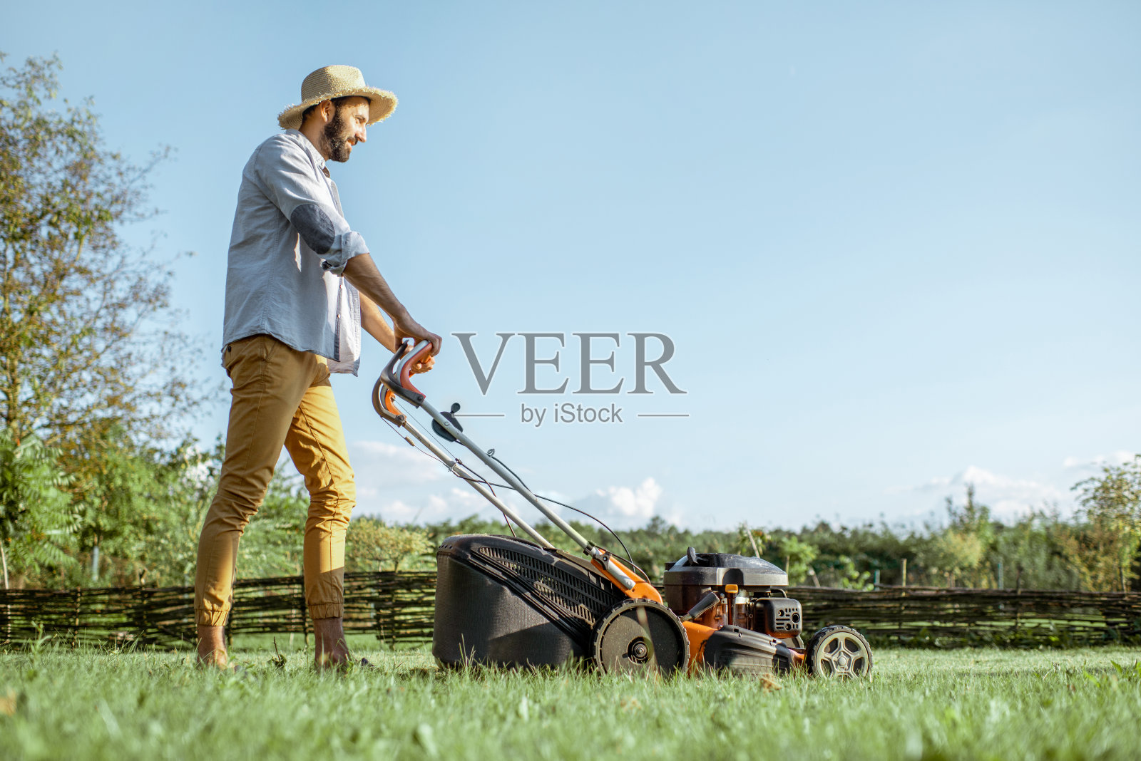 后院有个割草机的男人照片摄影图片