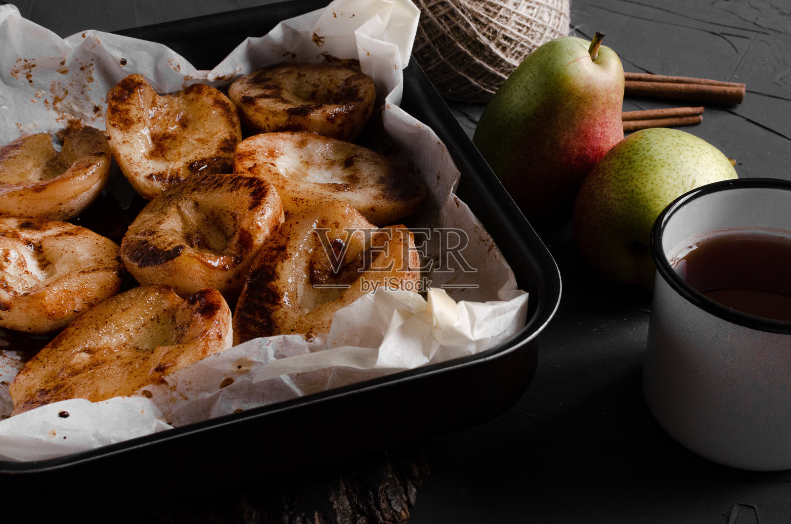 焦糖梨-水煮梨与香料在糖浆照片摄影图片