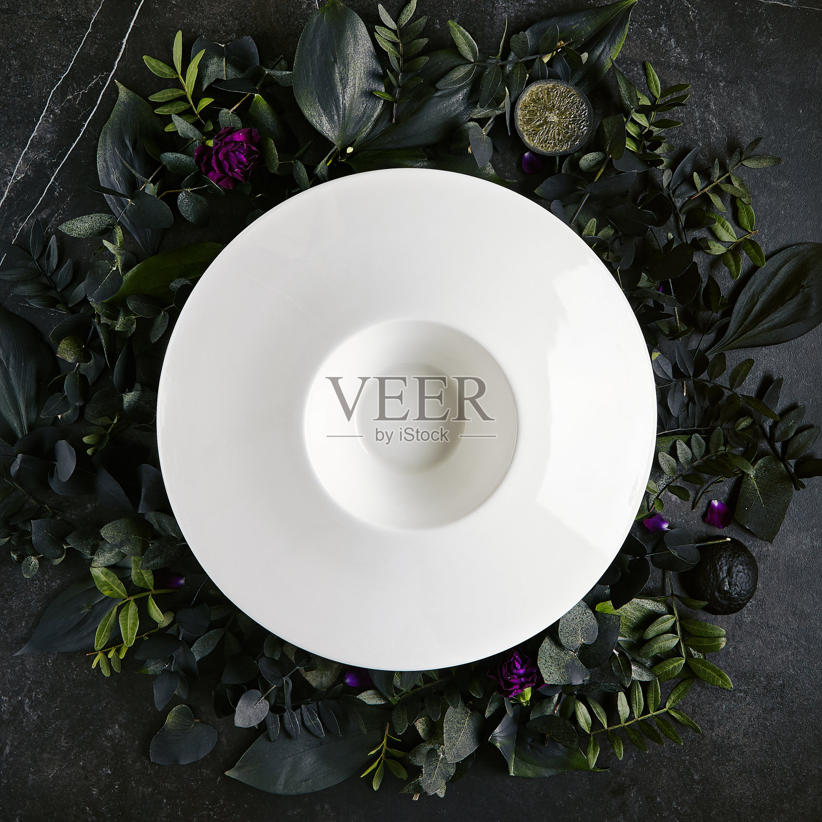 精致的服务白色餐厅板模板上天然深色石材和树叶背景照片摄影图片