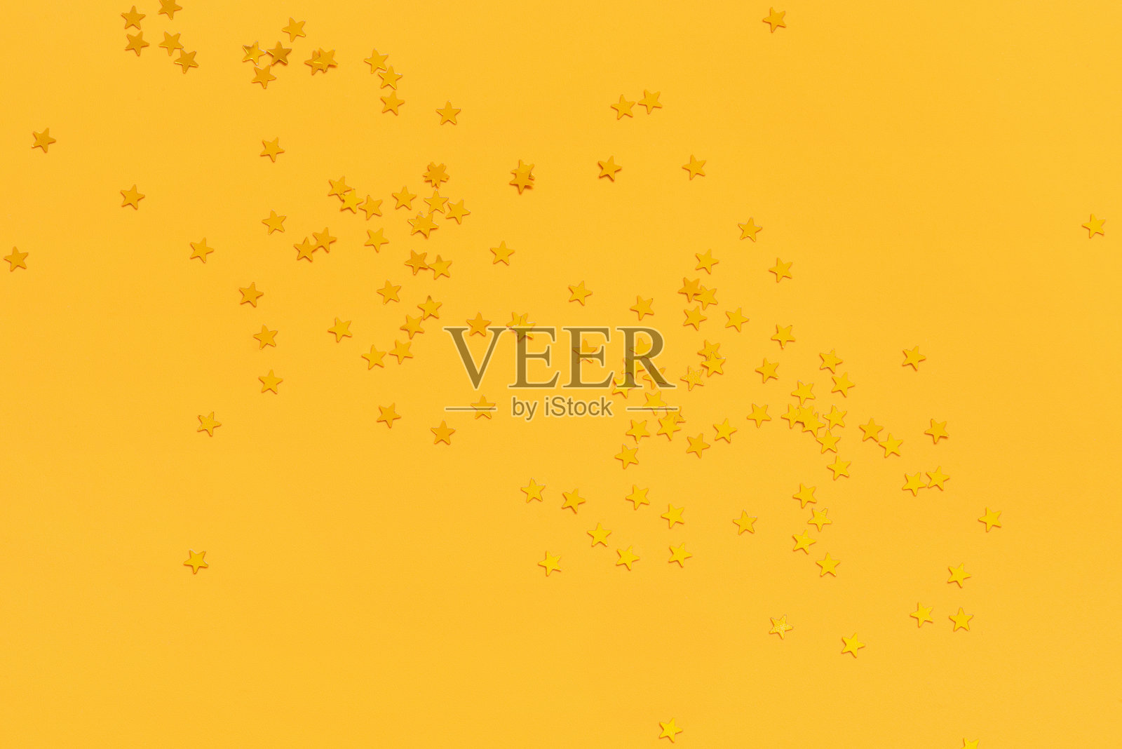 明亮的黄色背景上有金色的星星照片摄影图片
