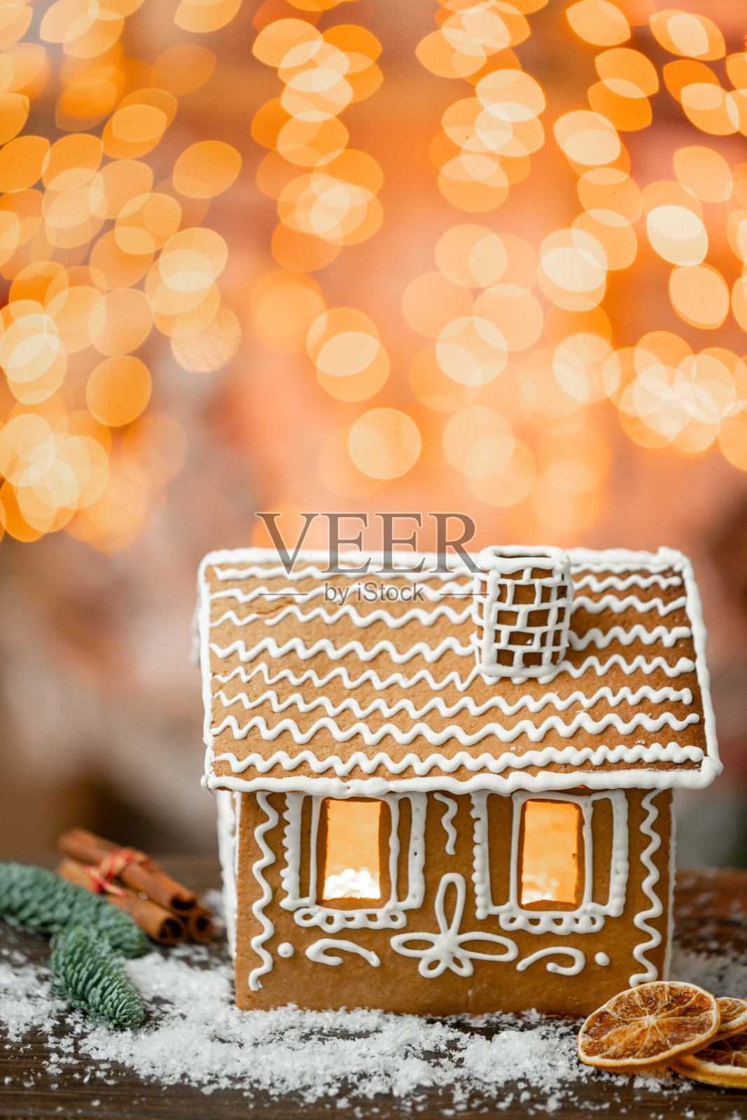 姜饼屋在桌子上。圣诞花环的散焦灯。早上在明亮的客厅。假期心情照片摄影图片