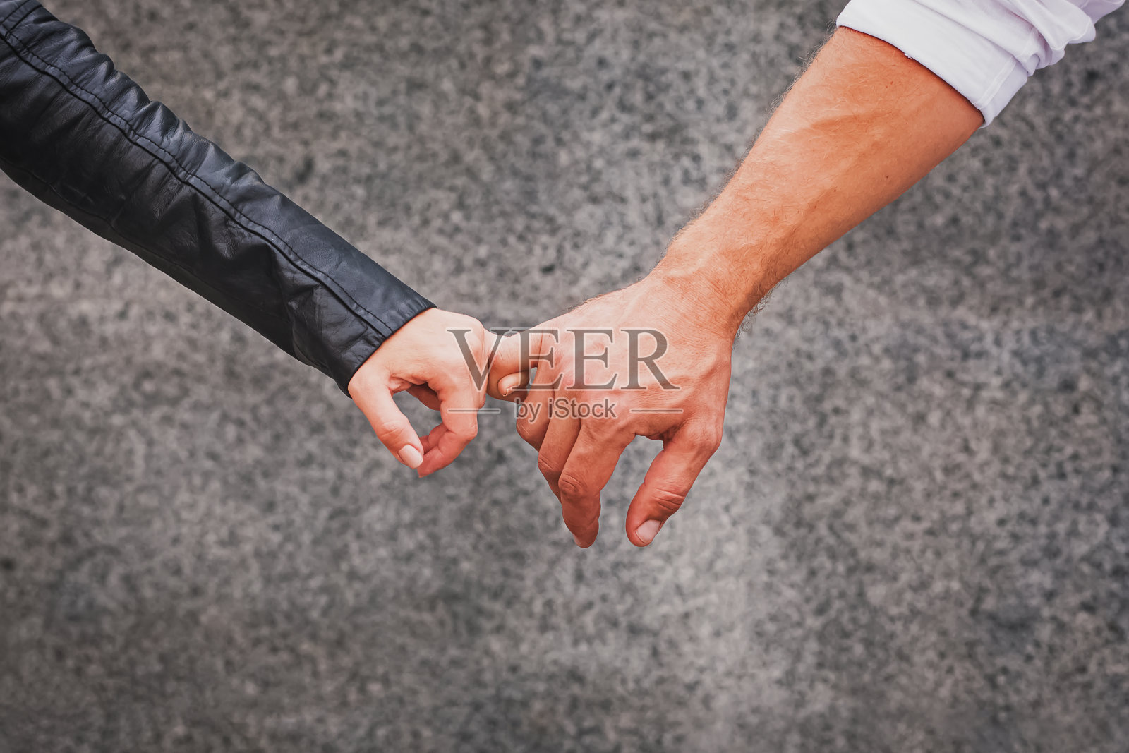 男人和女人的手把他们的小手指放在一起照片摄影图片