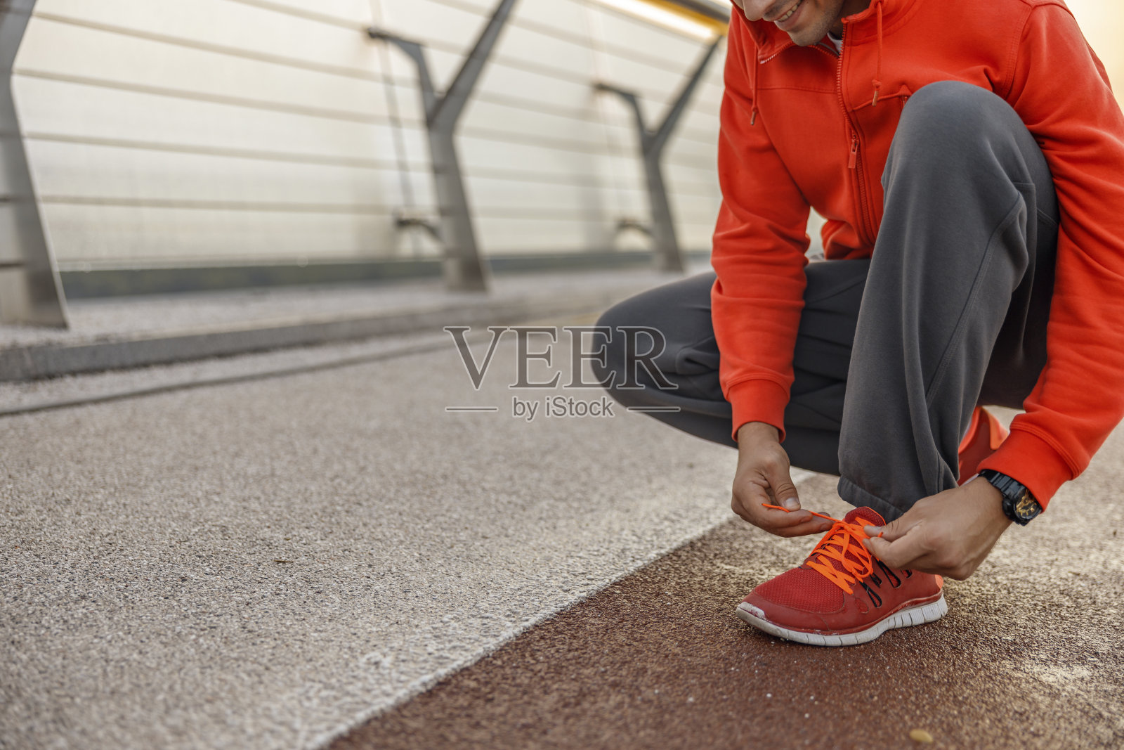 微笑的白人男性运动员系鞋带照片摄影图片