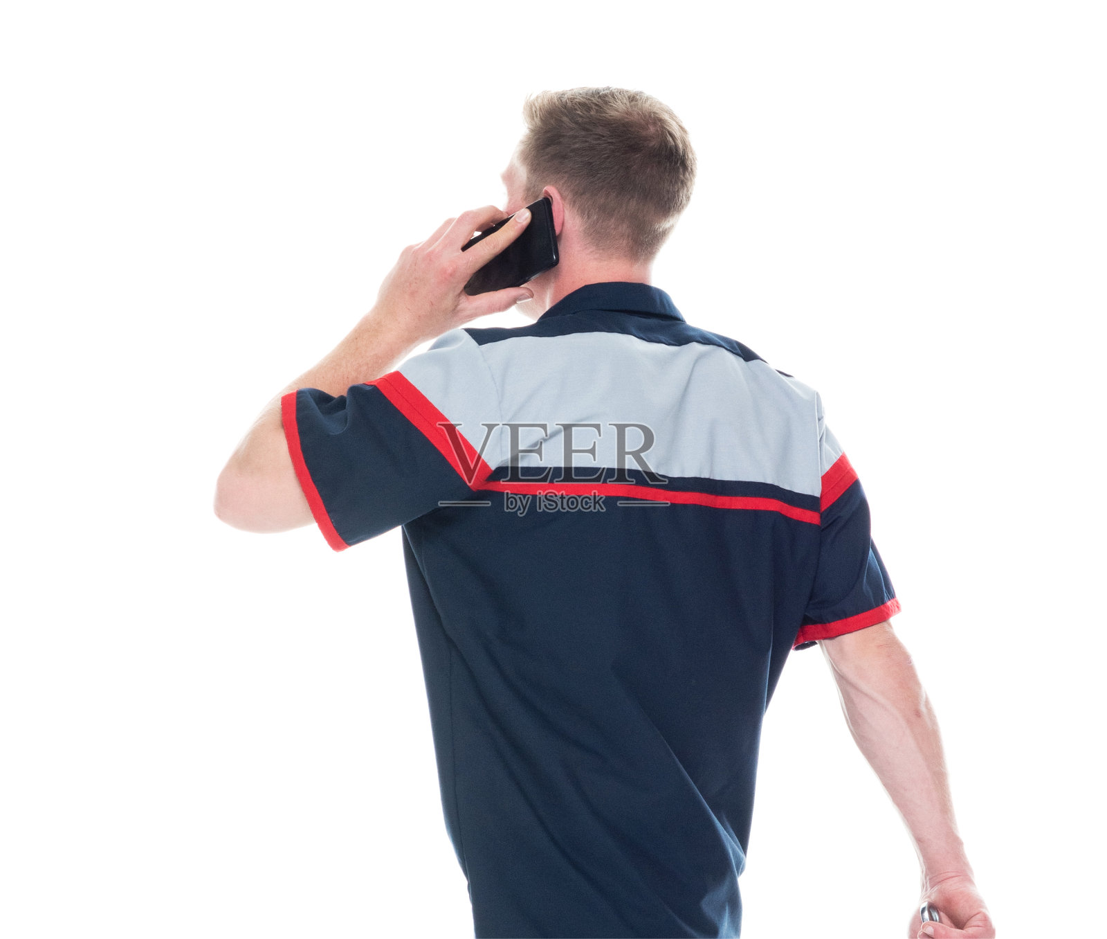 后视图/一人/腰部以上的20-29岁的成年英俊的人白种年轻男子/男性机械师/汽车技工/手工工人/修理工在白色背景下穿着制服谁正在说话和使用智能手机照片摄影图片