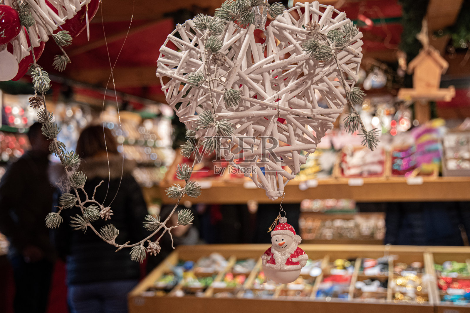 德国柏林圣诞市场,用冷杉树枝装饰的白色柳条心和雪人形状的圣诞装饰品。模糊背景的新年装饰品照片摄影图片