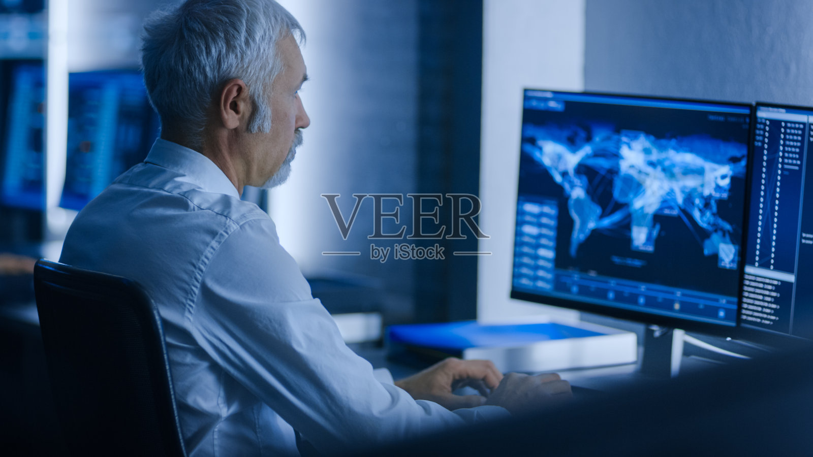 在系统控制室的工作站使用个人电脑工作的技术专家团队。照片摄影图片