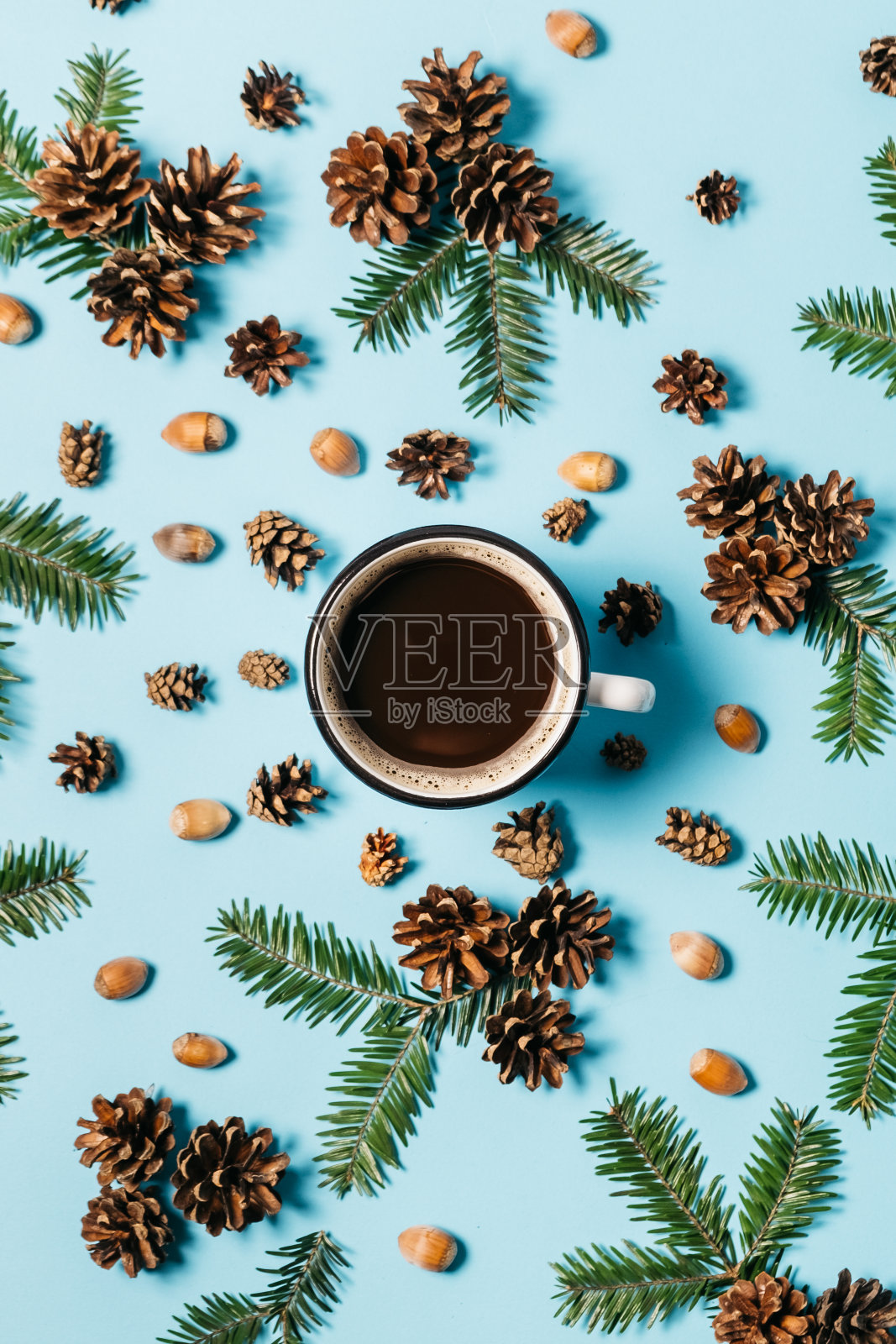 圣诞节或冬天的作文。框架由冷杉树枝,杯咖啡,松树,橡子在柔和的蓝色背景。圣诞节,冬天,新年的概念。平铺,俯视图,拷贝空间照片摄影图片