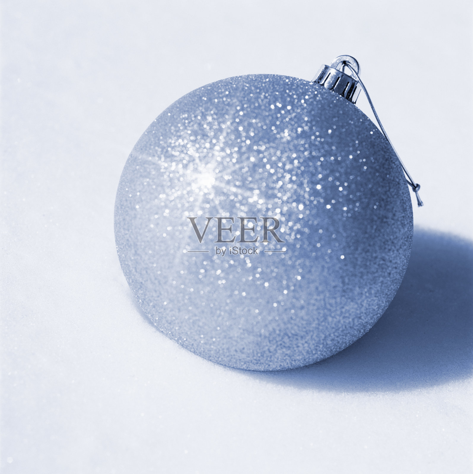 特写大,闪闪发光,银光闪闪的圣诞装饰品装饰在白色的雪背景。简约、现代、奢华的度假理念。照片摄影图片