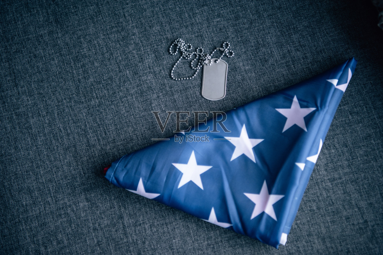 在家的沙发上放着打Tag的狗和折叠的美国国旗照片摄影图片