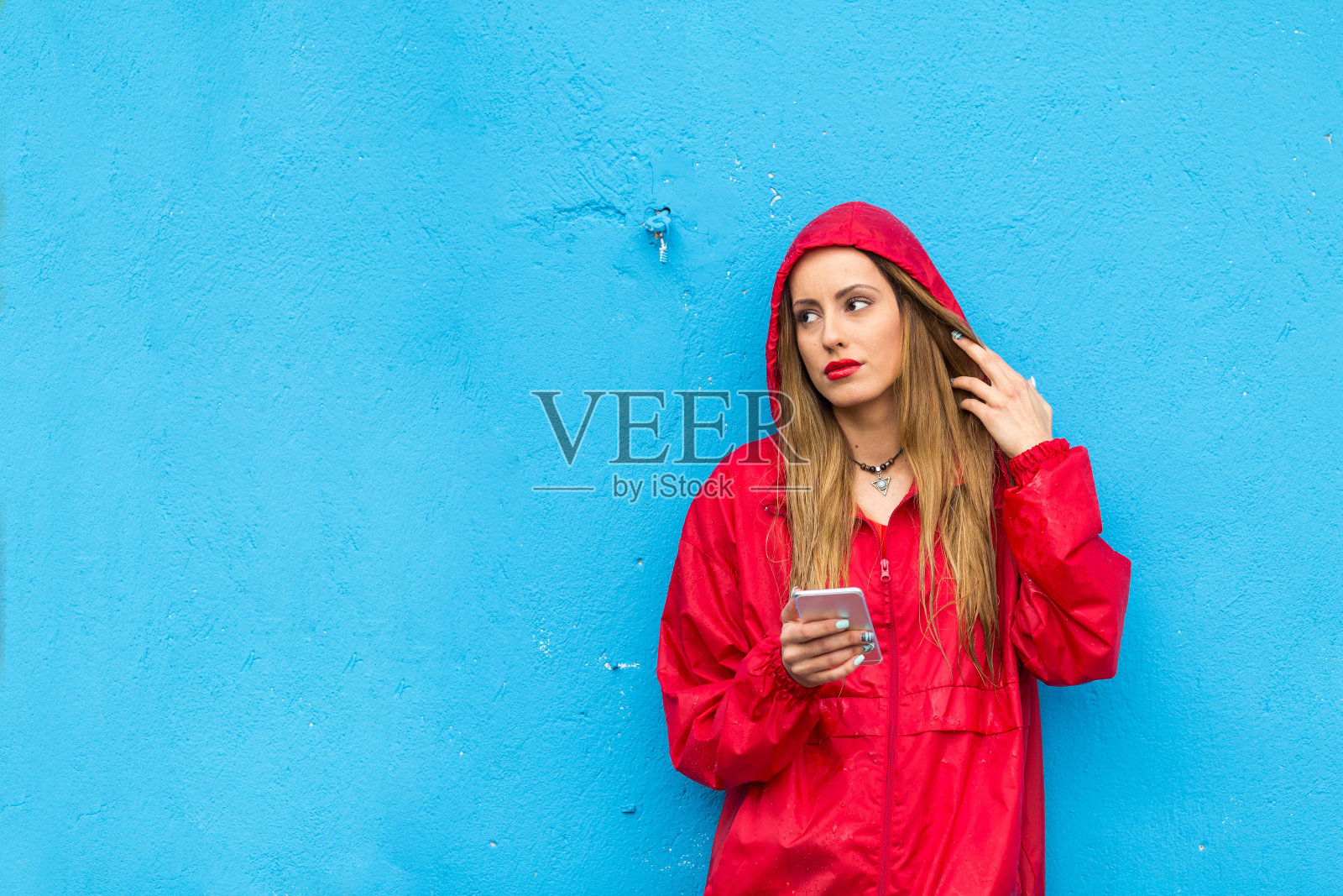 年轻女子在雨中使用智能手机照片摄影图片