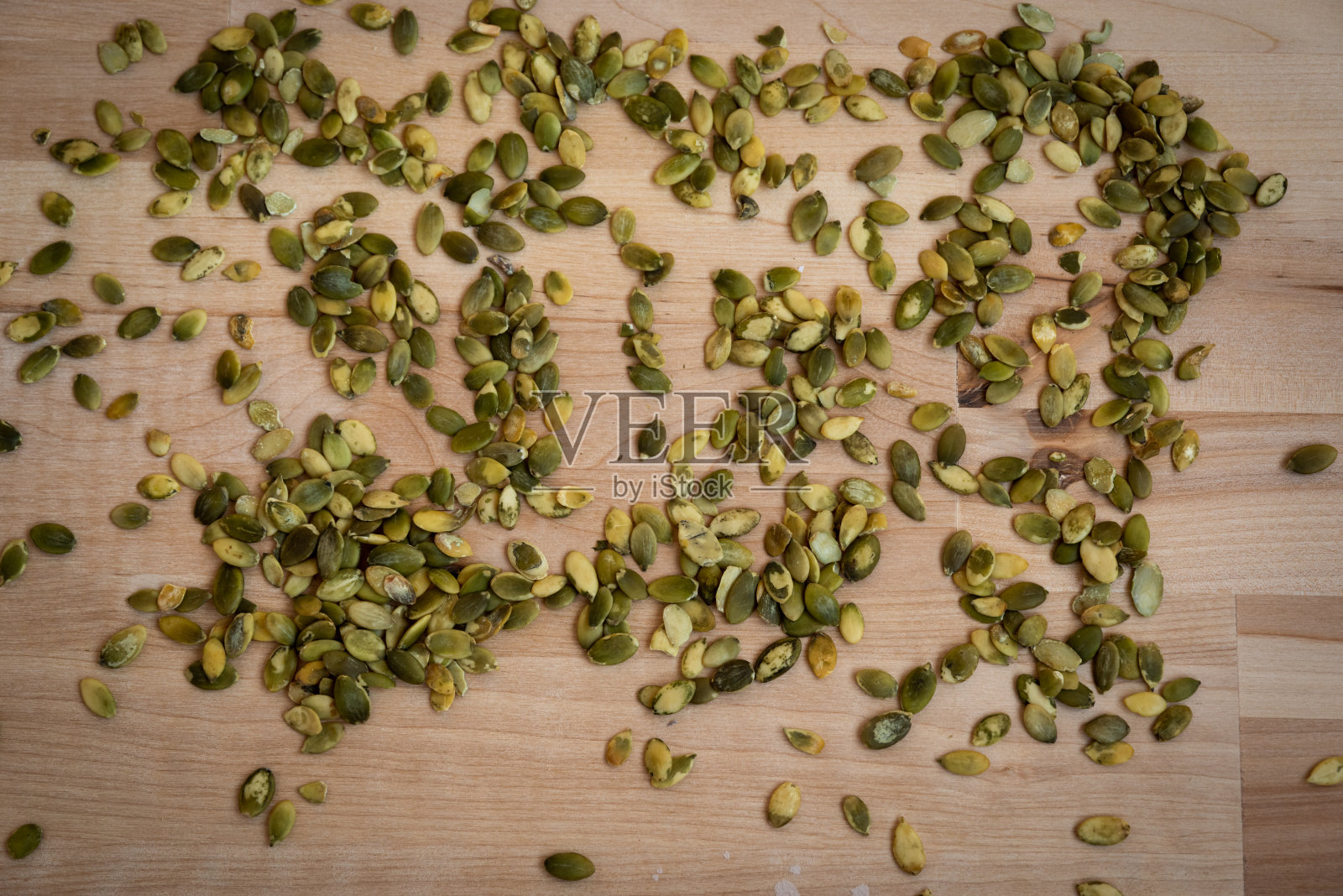 木桌上到处都是南瓜籽。自然景观和光线照片摄影图片