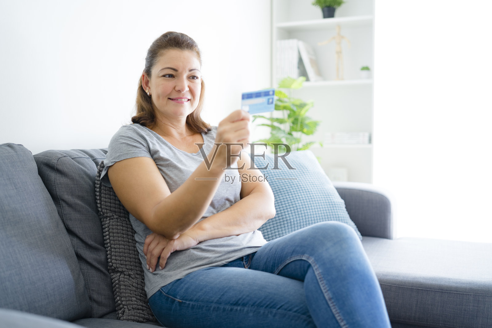 坐在沙发上网上购物的女人照片摄影图片