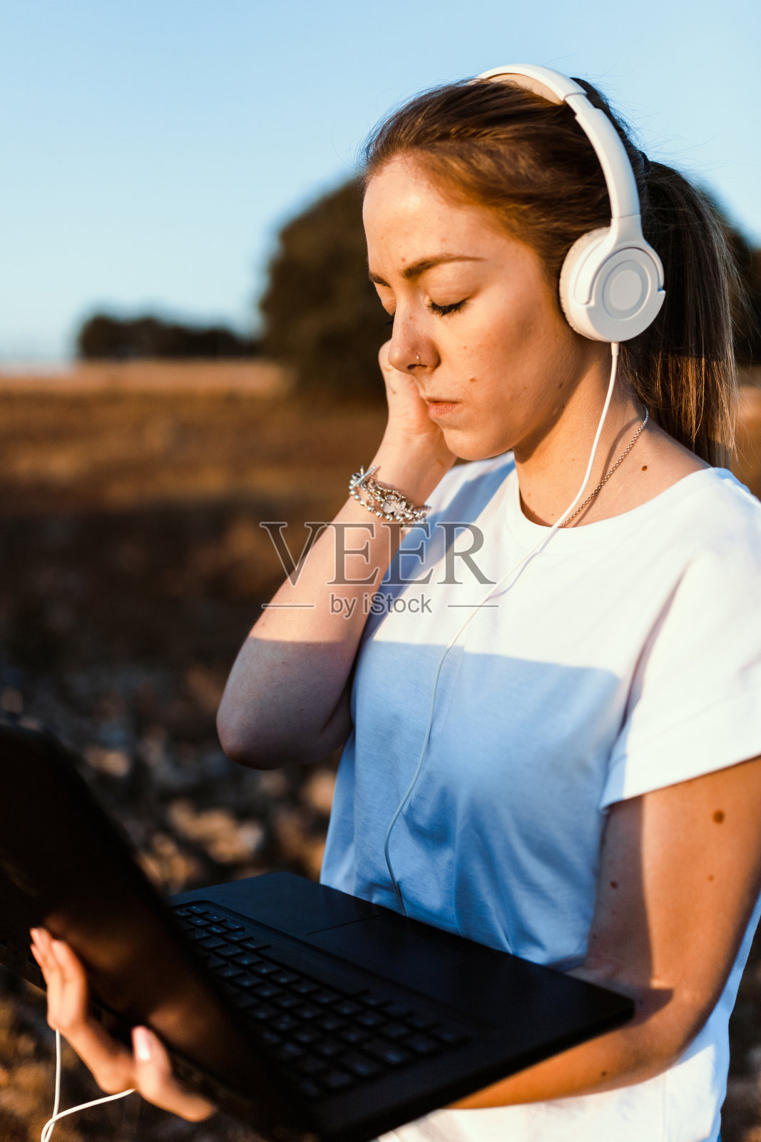 一个年轻女子用她的笔记本电脑监听外部通讯照片摄影图片