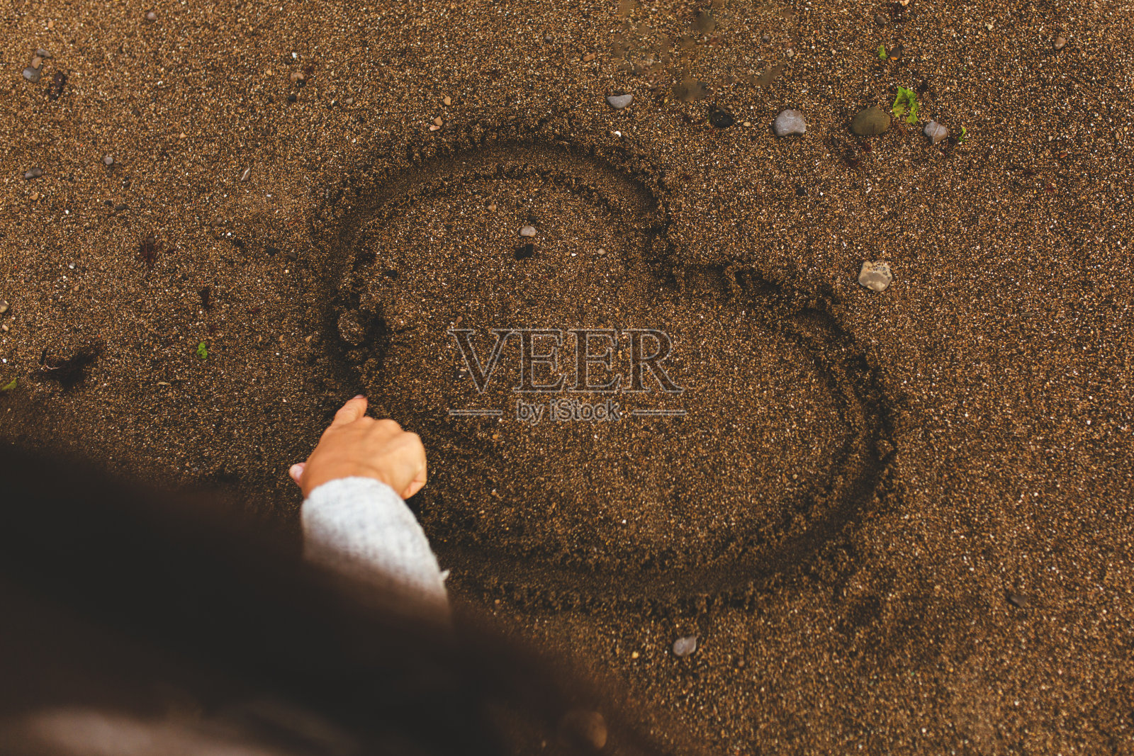 沙滩上的女孩在沙滩上画心形照片摄影图片