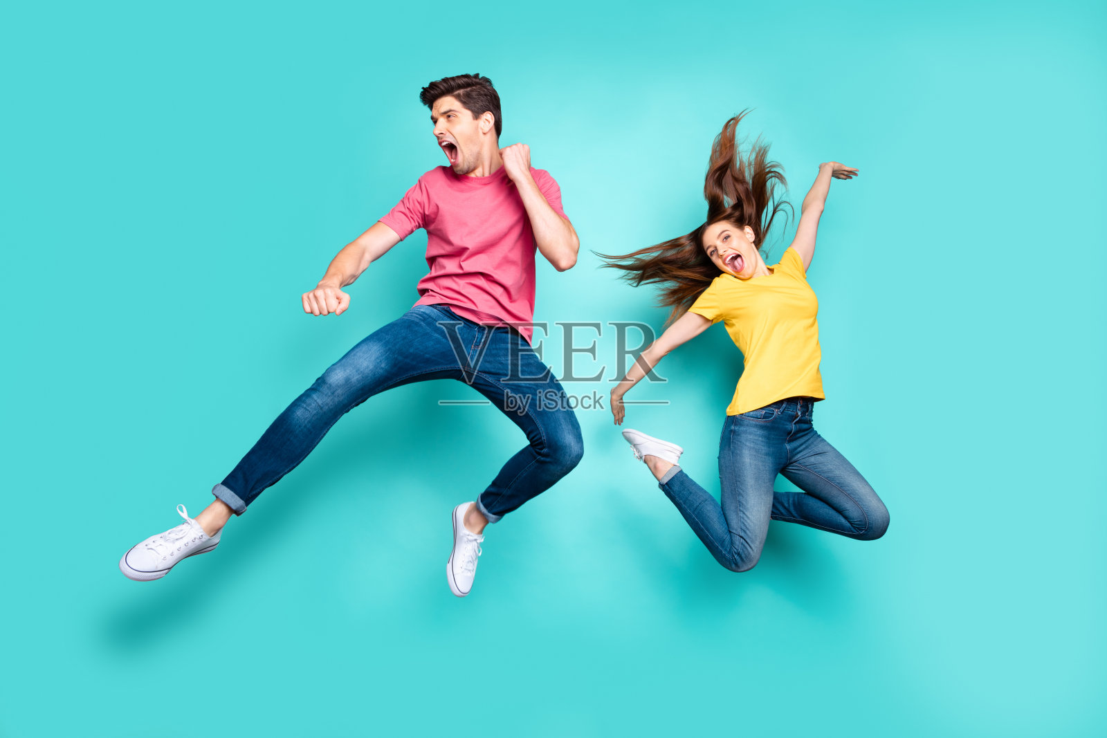 他的,他的,她的,她的,漂亮的,有吸引力的,疯狂的,时髦的,快乐的一对夫妇在空中跳跃,有乐趣的,开玩笑的,快乐的孤立在明亮的,生动的,闪亮的,充满活力的,绿色的,蓝绿色的背景上照片摄影图片