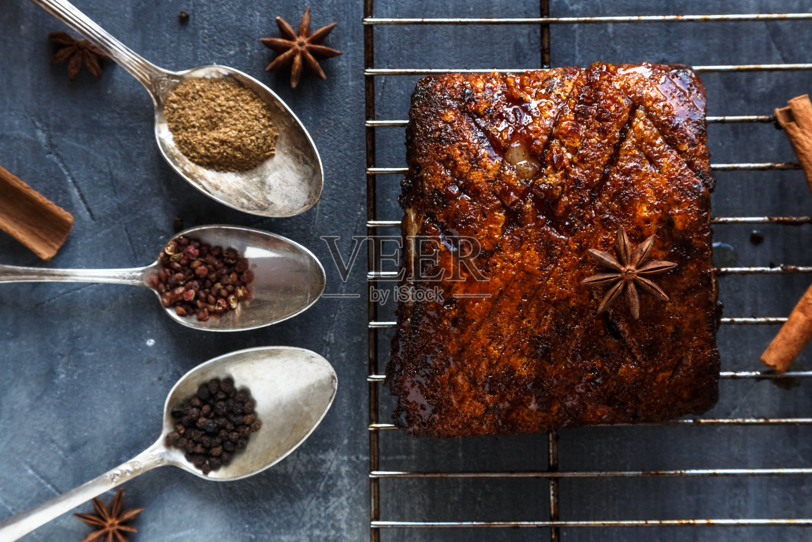 中国脆皮五花肉在深色混凝土背景与香料,复制空间照片摄影图片