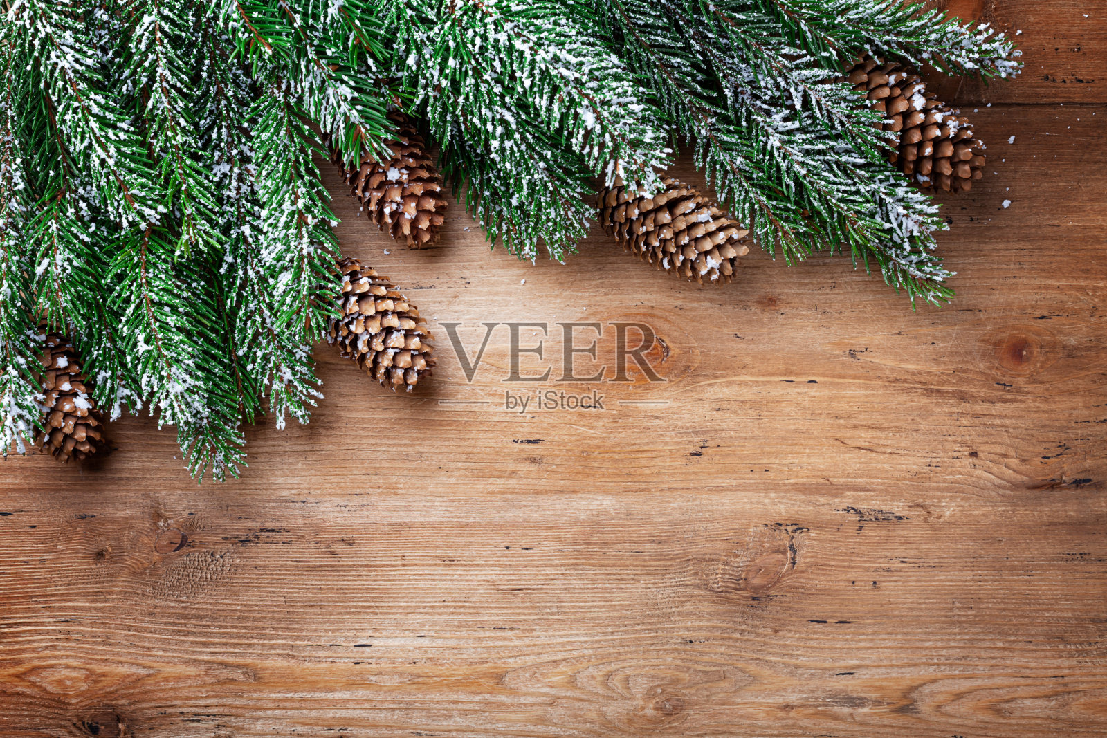 圣诞节的背景。雪冷杉树枝与冷杉球果在木板上。带有文本空间的俯视图。照片摄影图片