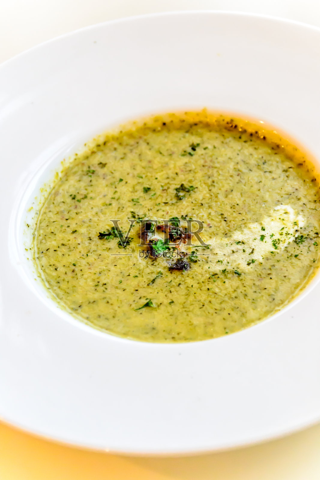 奶油花椰菜汤,配熏肉块,盛在白色的中国汤盘里照片摄影图片