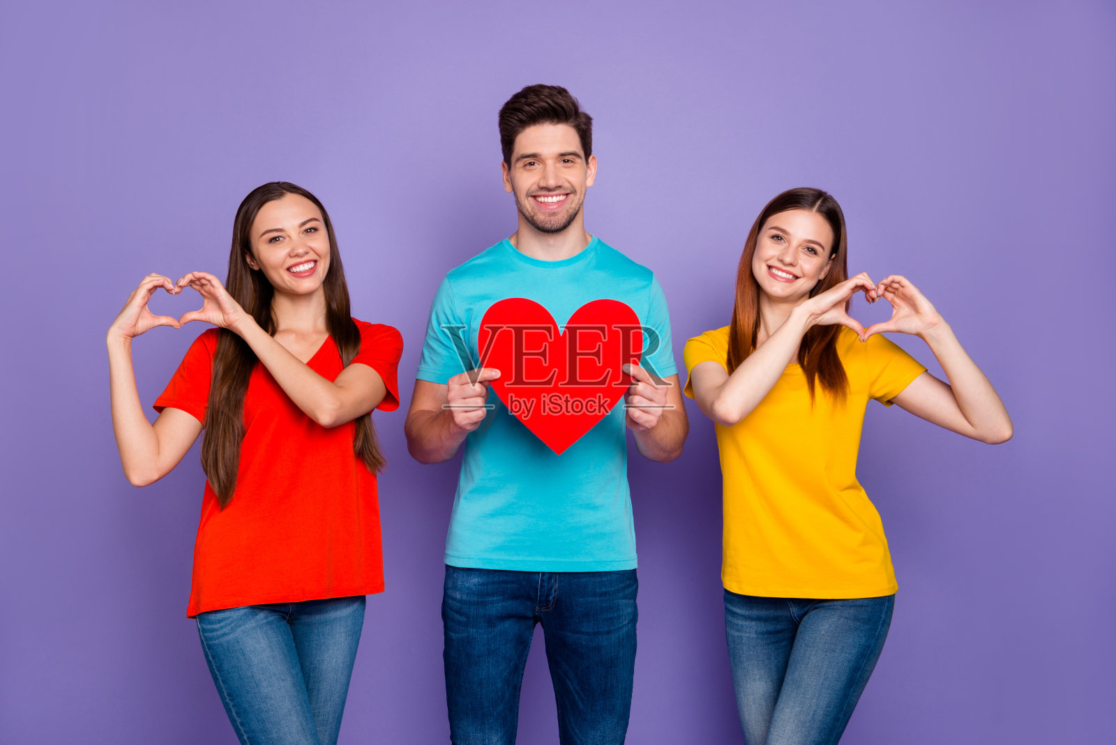 照片的一个英俊的潮人和两个可爱的甜蜜的女士使手和手指的心孤立的紫罗兰背景照片摄影图片