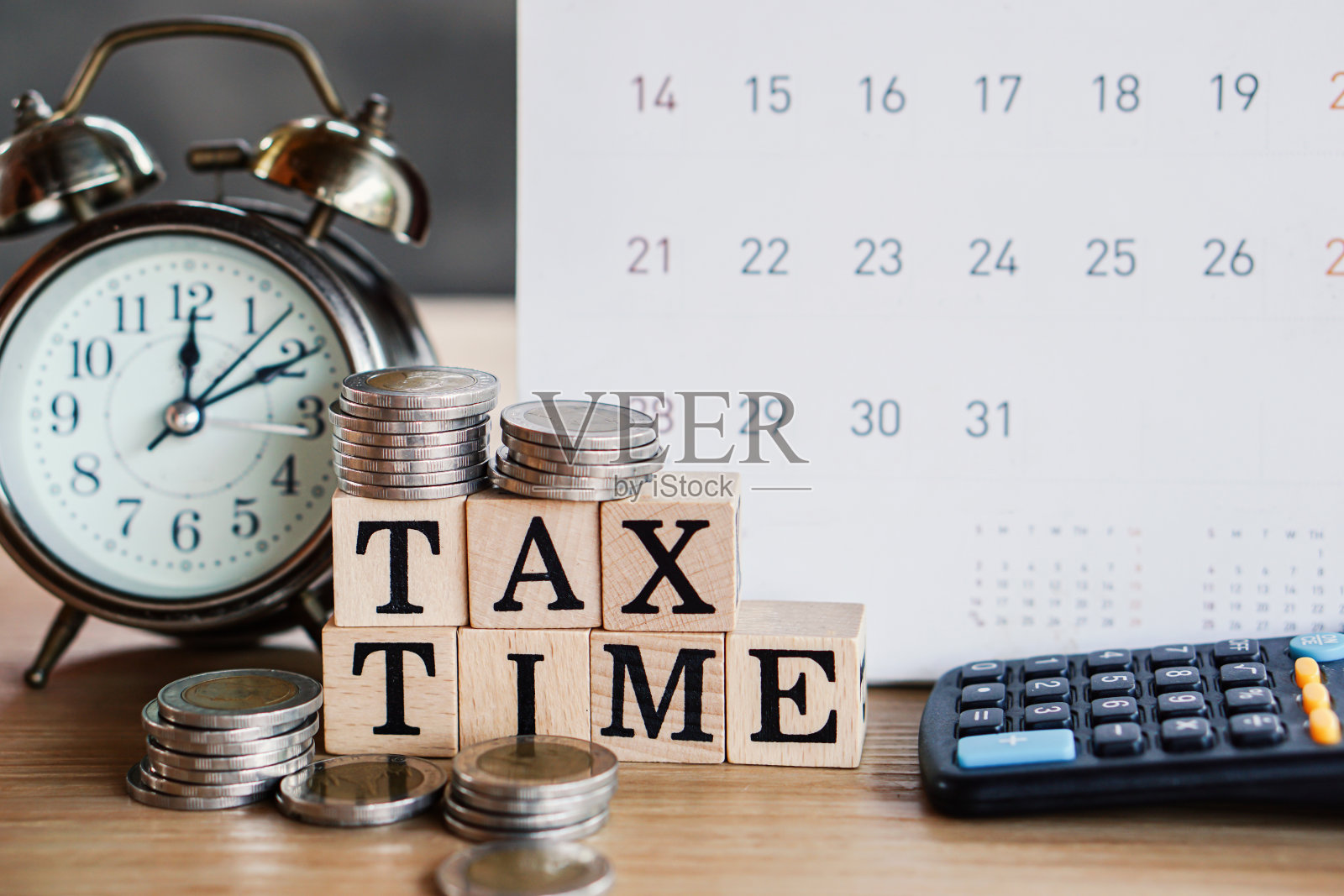 税务时间概念与日历,时钟,硬币和计算器在桌上照片摄影图片