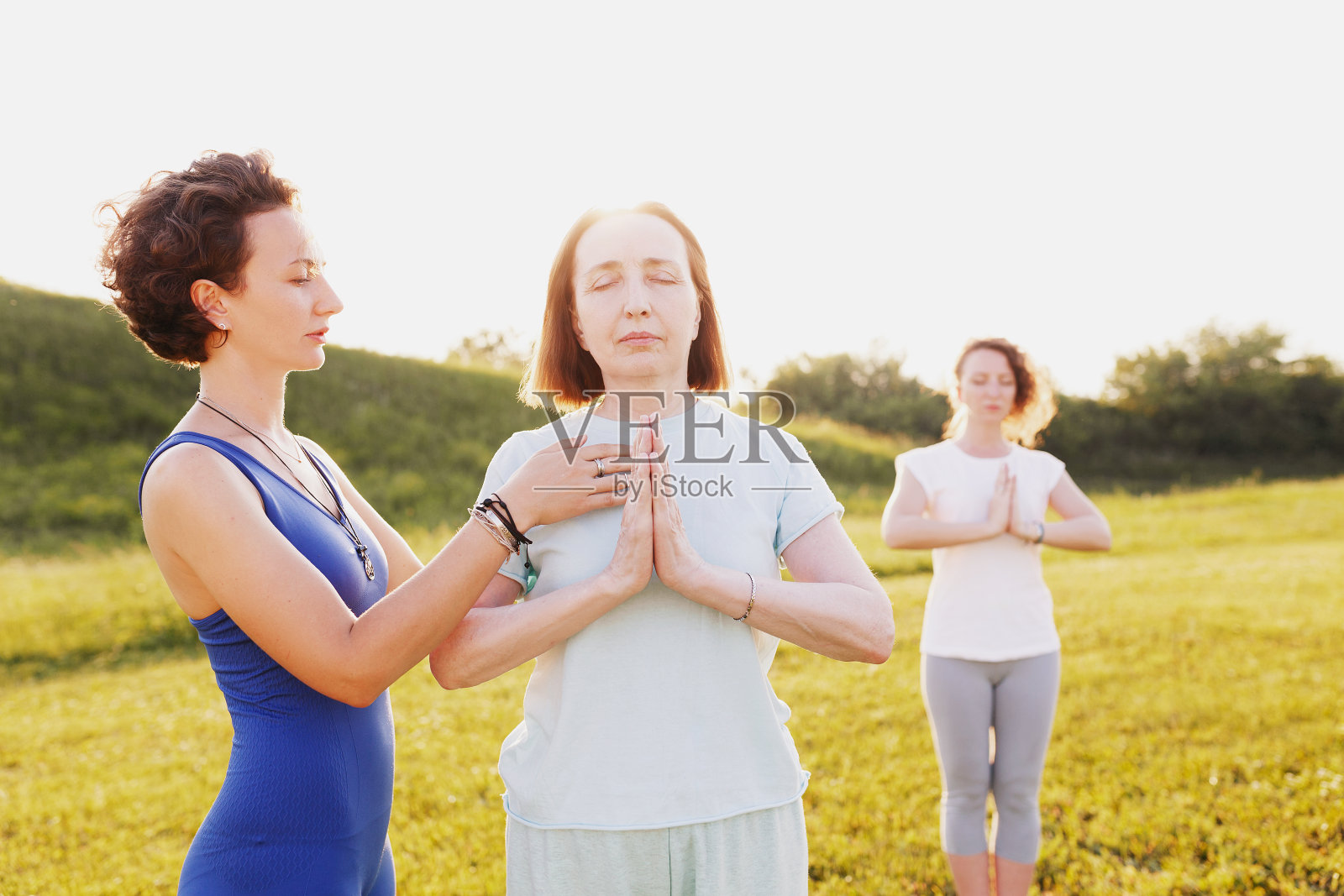 母亲和两个年幼的女儿在做瑜伽照片摄影图片