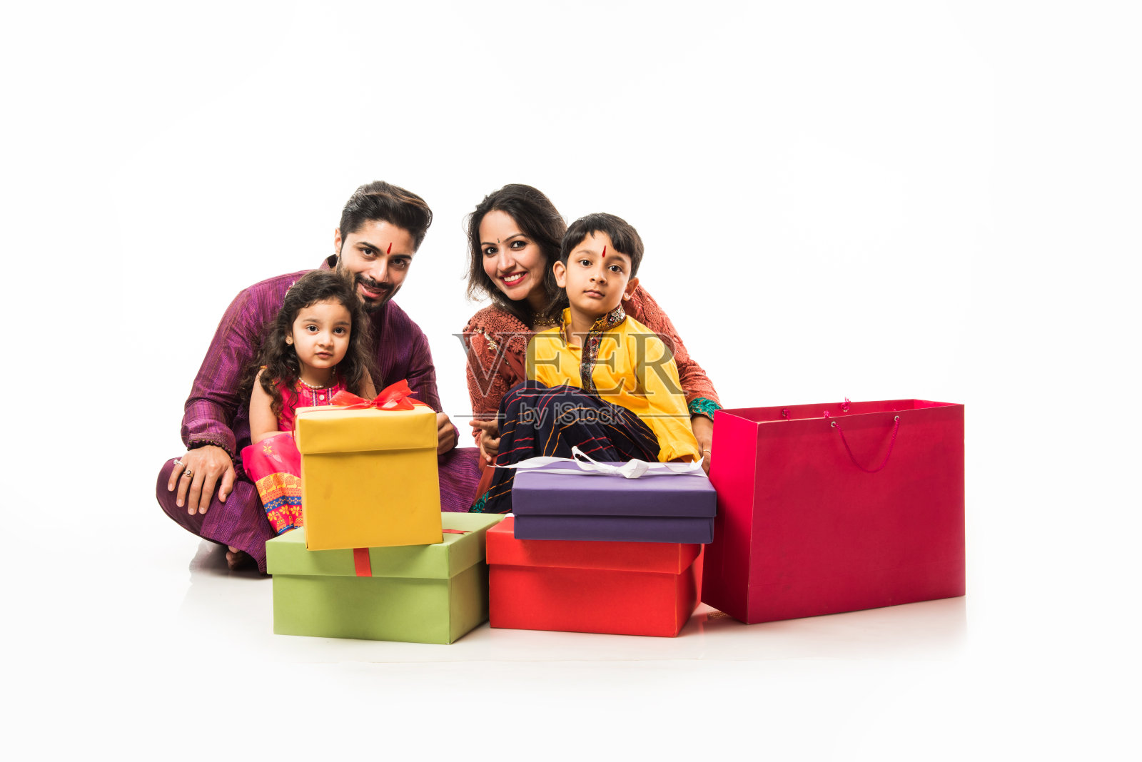 印度四口之家庆祝排灯节与礼盒和diya盘而穿着民族服装照片摄影图片