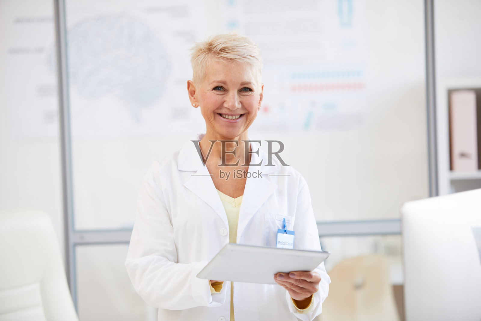 在医学会议上使用数字平板电脑的快乐美丽的女性神经学家的肖像照片摄影图片