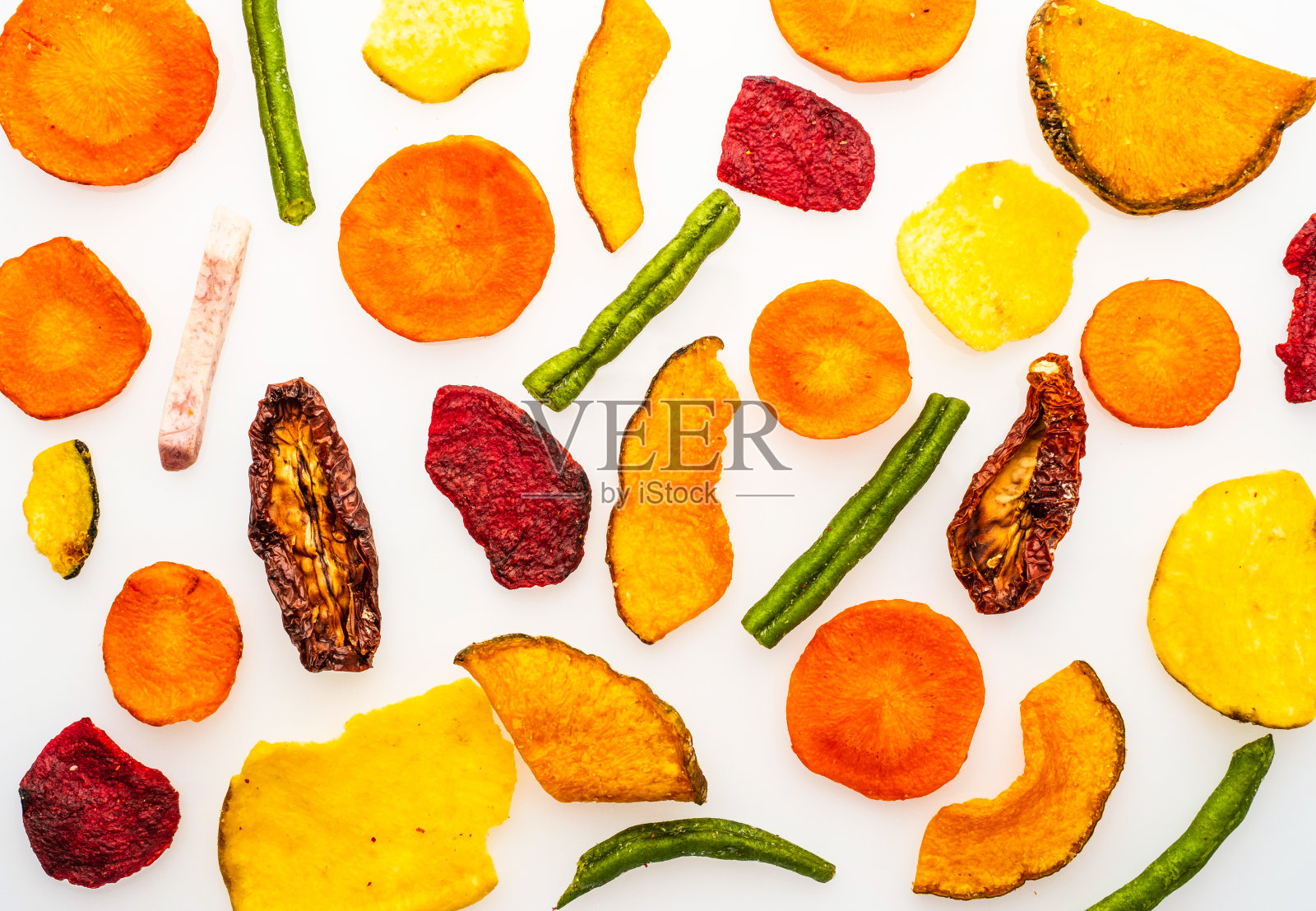 从胡萝卜,甜菜,防风草和其他蔬菜中分离出来的干蔬菜片,在白色背景上。有机饮食和素食照片摄影图片