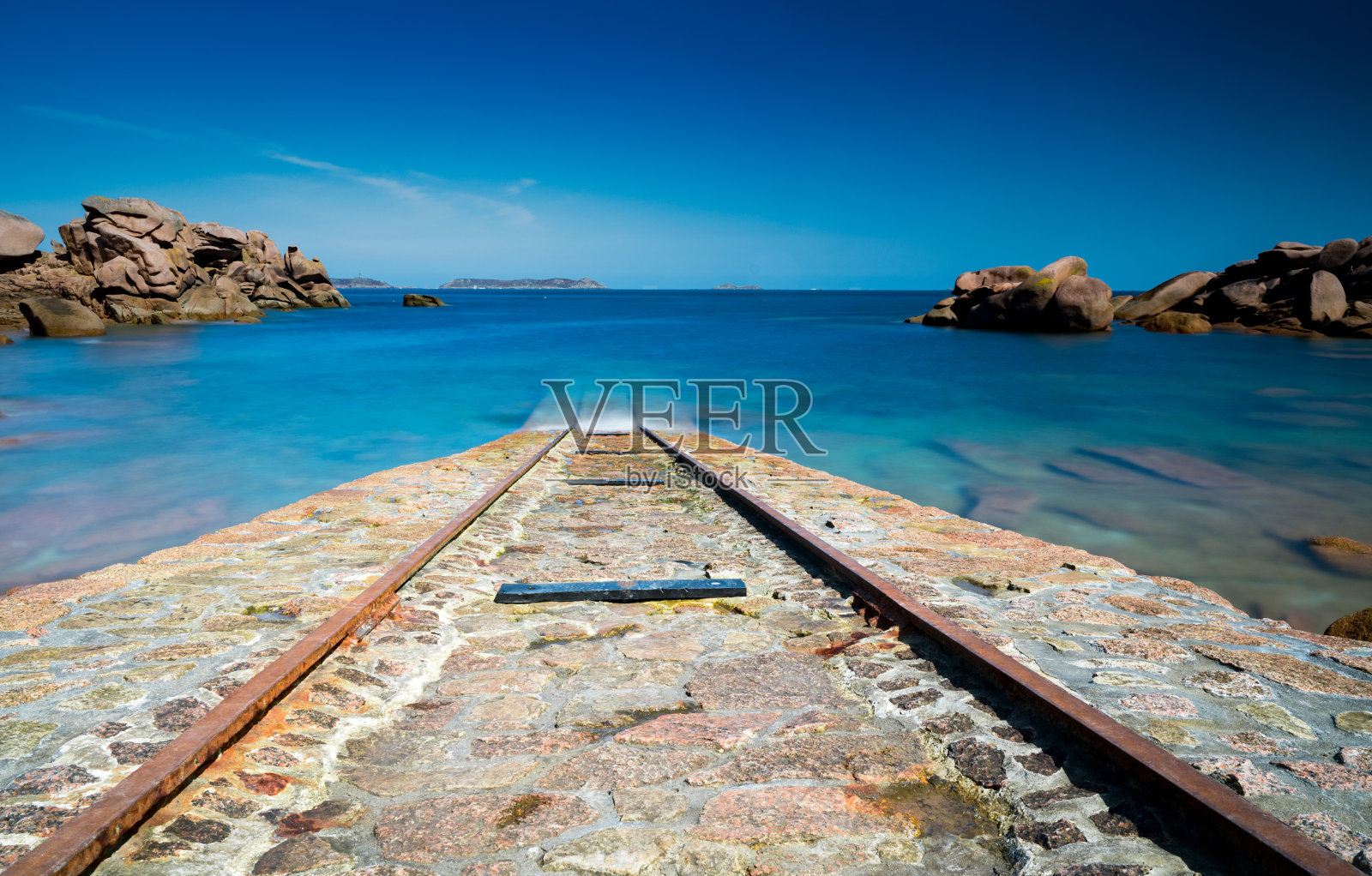 在布列塔尼海岸,古老的石船坡道通向平静的蓝色海洋照片摄影图片