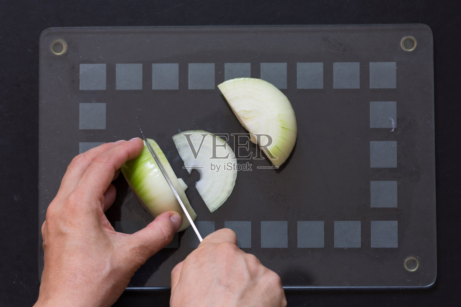 女人用刀切洋葱的俯视图照片摄影图片