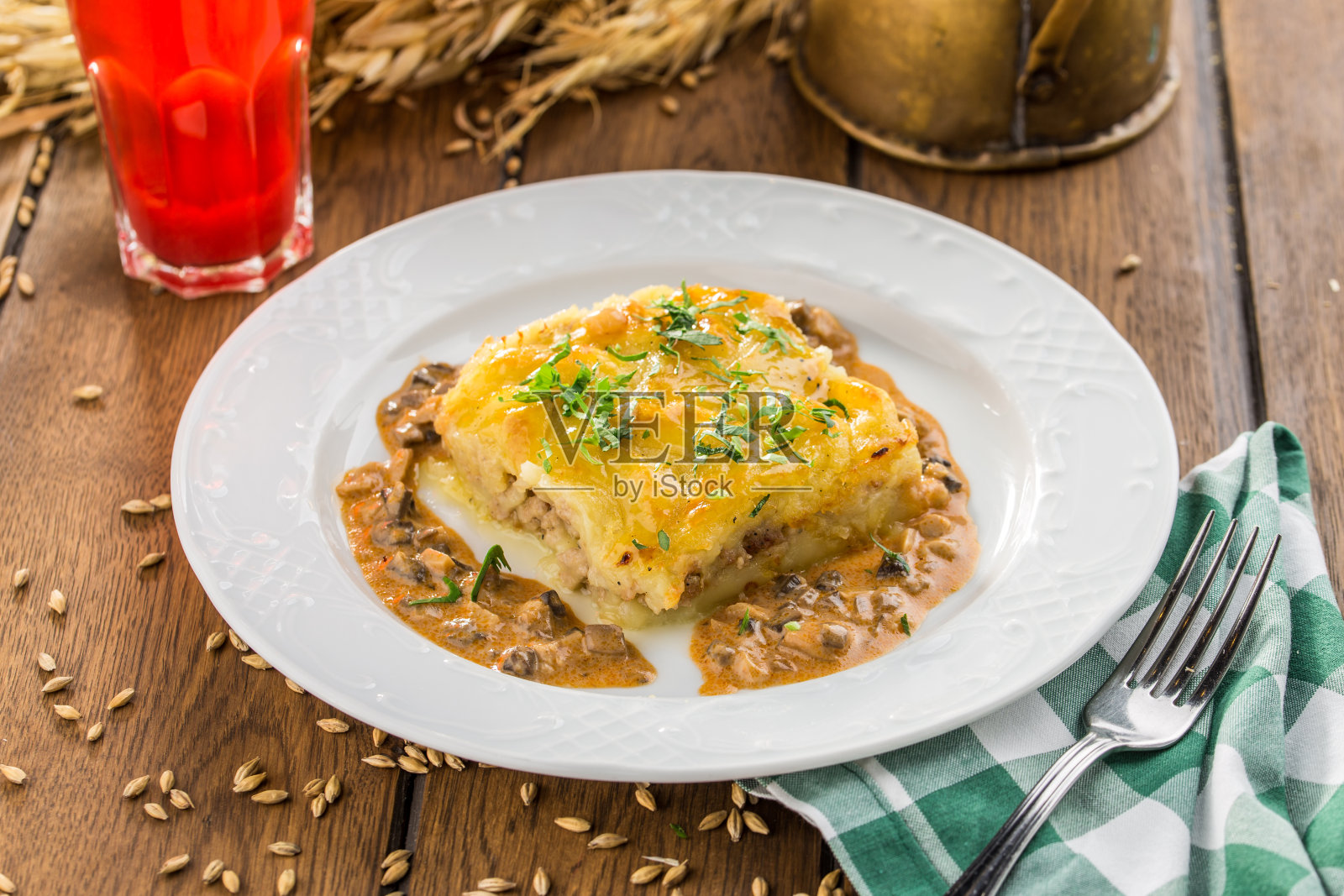 木桌上盛有土豆砂锅和浆果饮料照片摄影图片