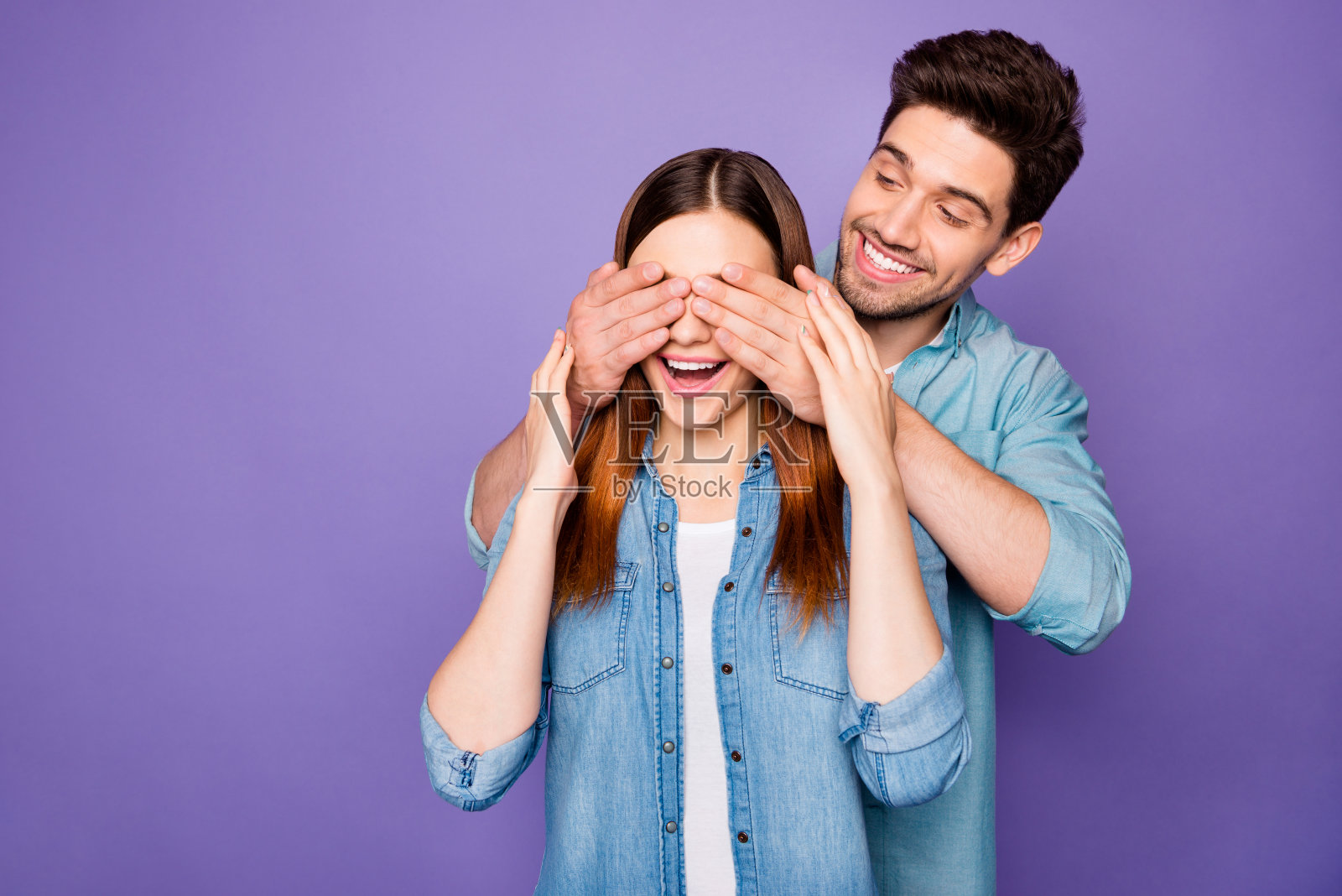 肖像的两个时髦的男人闭上眼睛给他留下深刻印象的女孩有浪漫的约会假日穿着风格的衣服孤立在紫罗兰色的背景照片摄影图片