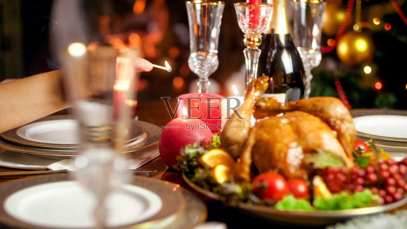 年轻女子在客厅的家庭圣诞餐桌上点燃蜡烛的特写图像照片摄影图片