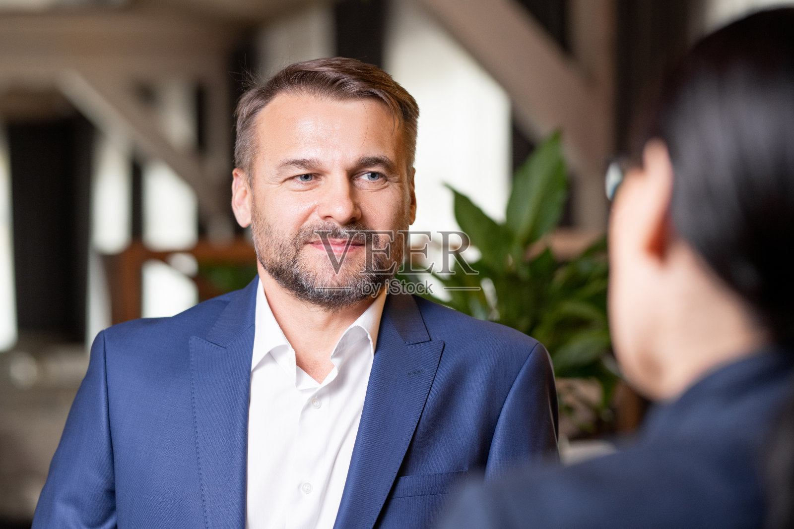 快乐的大胡子商人在优雅的西装与同事讨论照片摄影图片