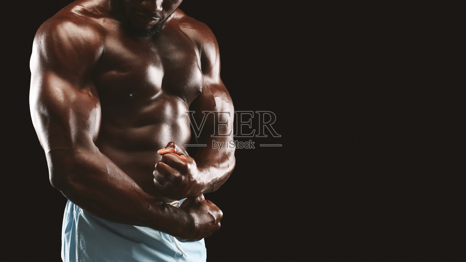 强壮的二头肌和胸部的黑人健美运动员照片摄影图片