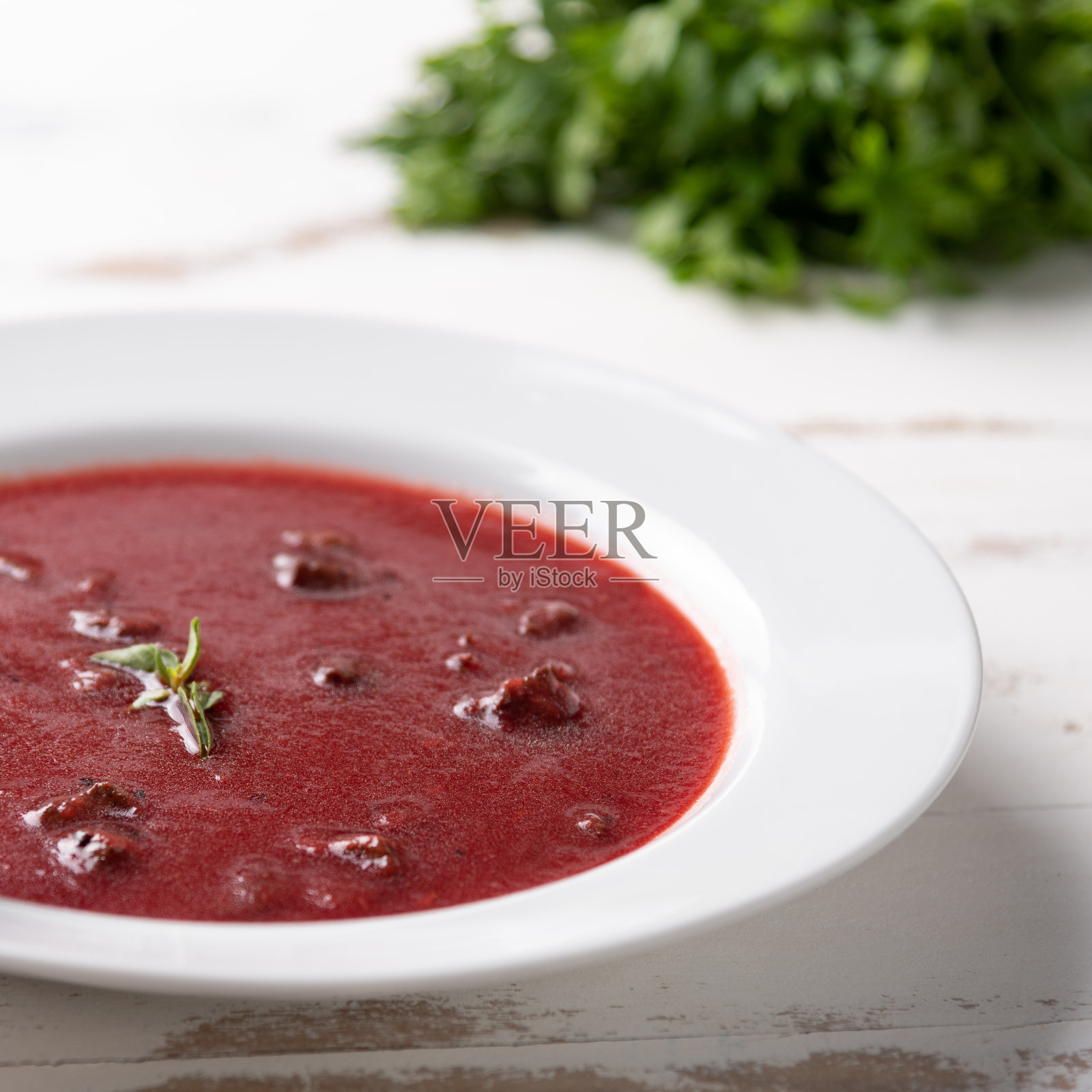 美味的甜菜汤与酸奶油在白色的盘子,在白色的木制桌子的背景。柔和的光。传统的乌克兰俄罗斯罗宋汤甜菜根汤照片摄影图片