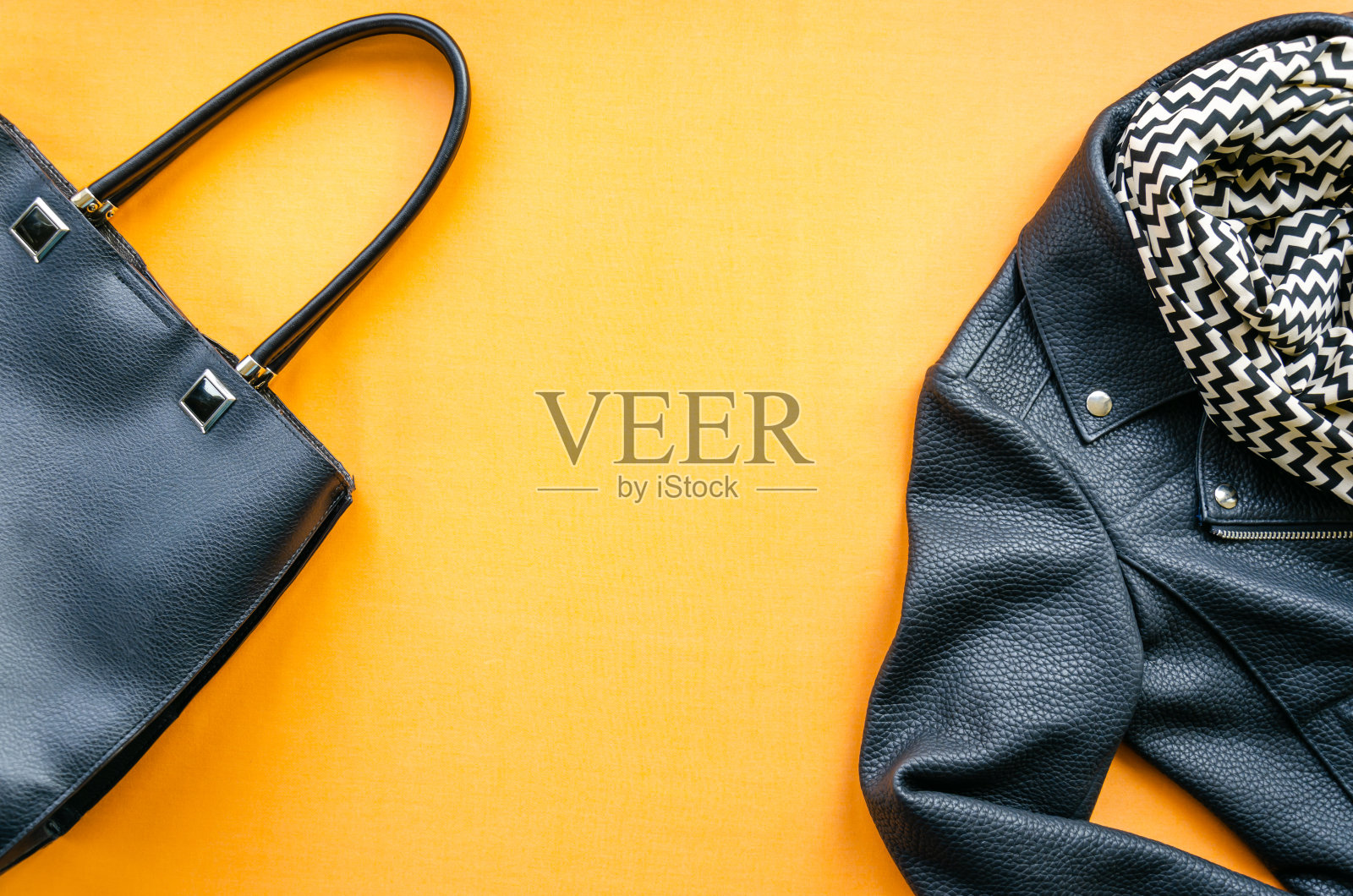 时尚女装套装:黄色底色的皮夹克、包包、围巾。时髦的外观。时尚的概念。前视图。平的。本空间照片摄影图片