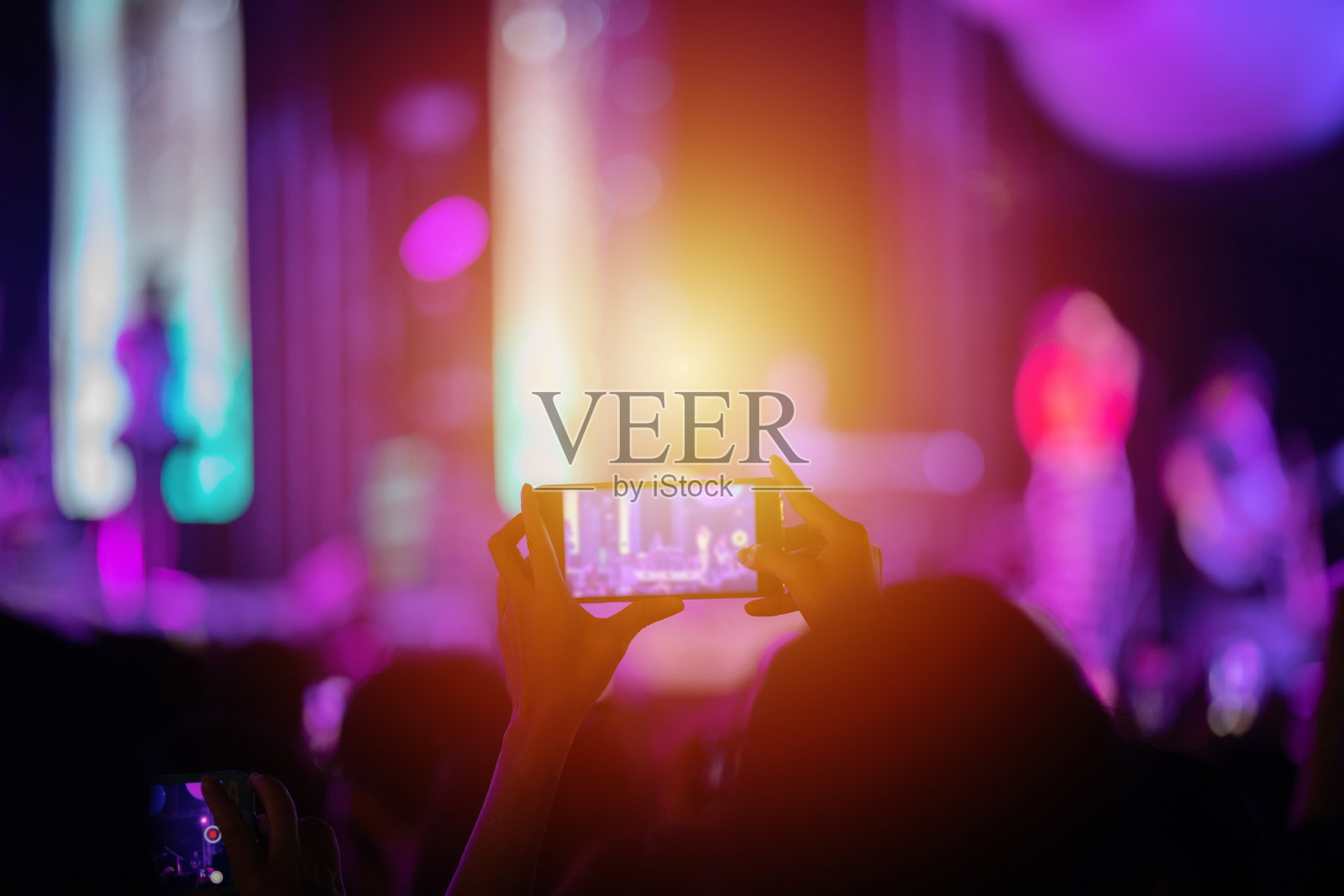 音乐会人群的剪影在后方的节日人群举起他们的手在明亮的舞台灯光照片摄影图片