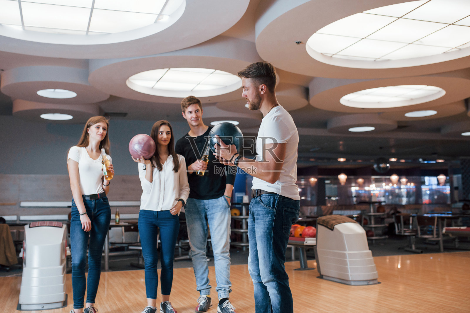 把之前做准备。快乐的年轻朋友们周末在保龄球俱乐部玩得很开心照片摄影图片
