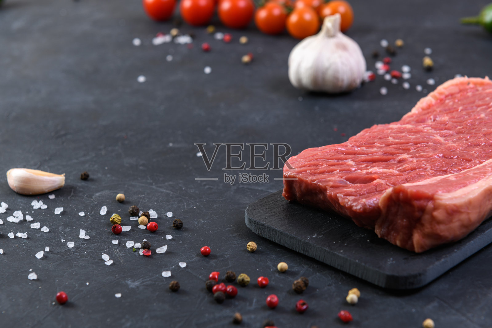 在黑色背景上放上新鲜的大理石肉和调味料照片摄影图片