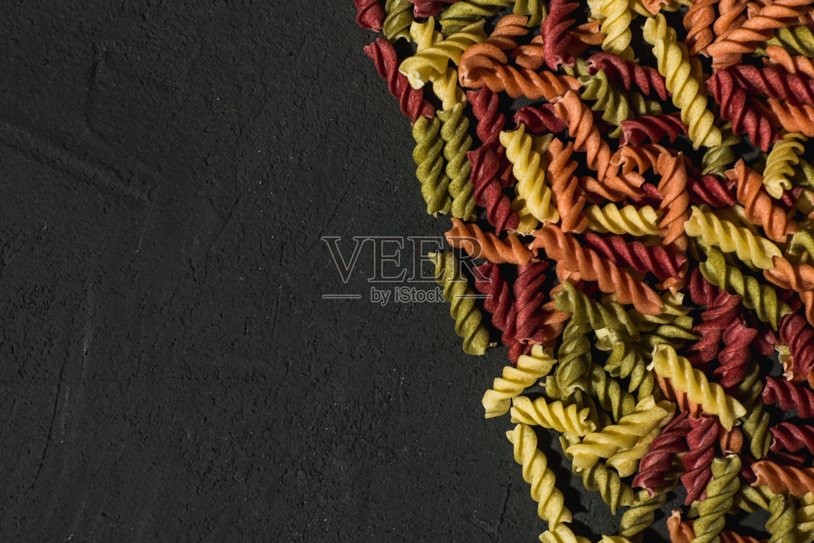 深色背景上的彩色素食意大利面照片摄影图片