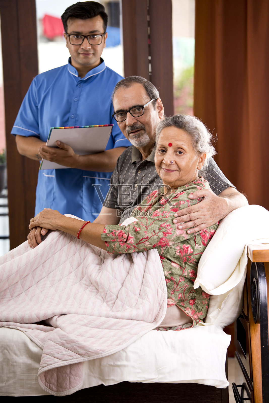 男护士在家记录老年病人照片摄影图片