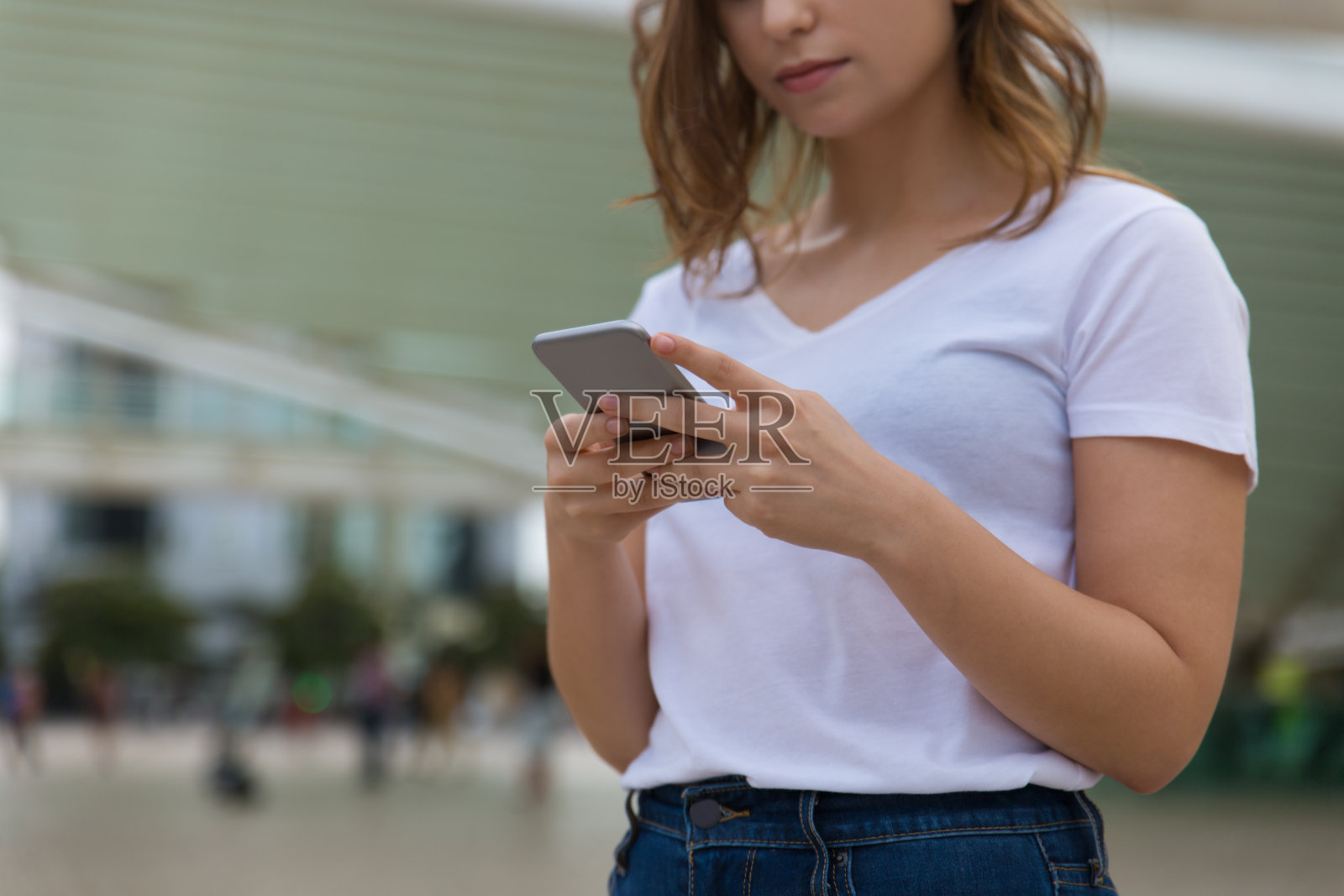 年轻女子手持现代手机的剪影照片摄影图片