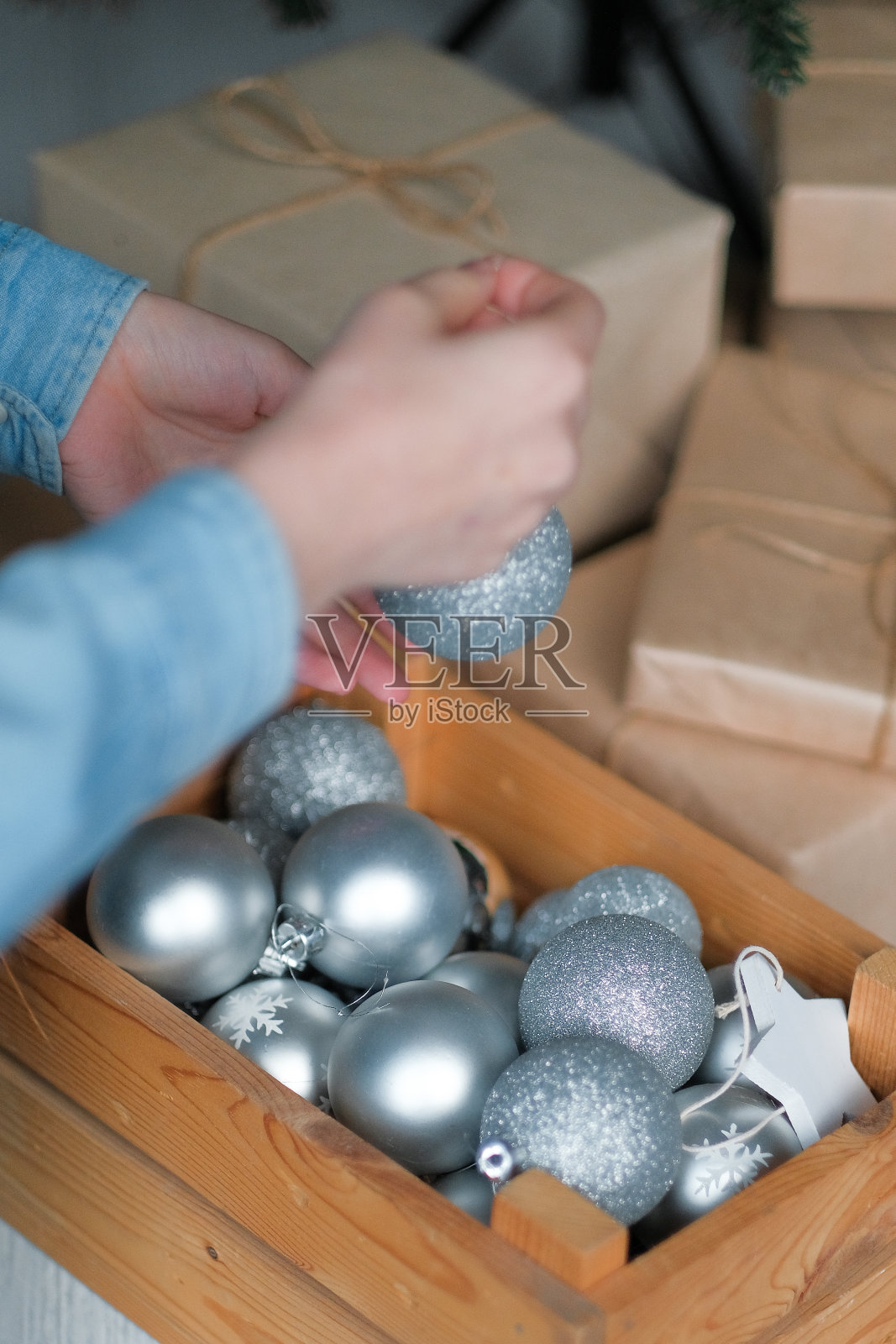 小女孩在室内装饰圣诞树。在纸包装礼品的背景下。圣诞节前的早晨。照片摄影图片