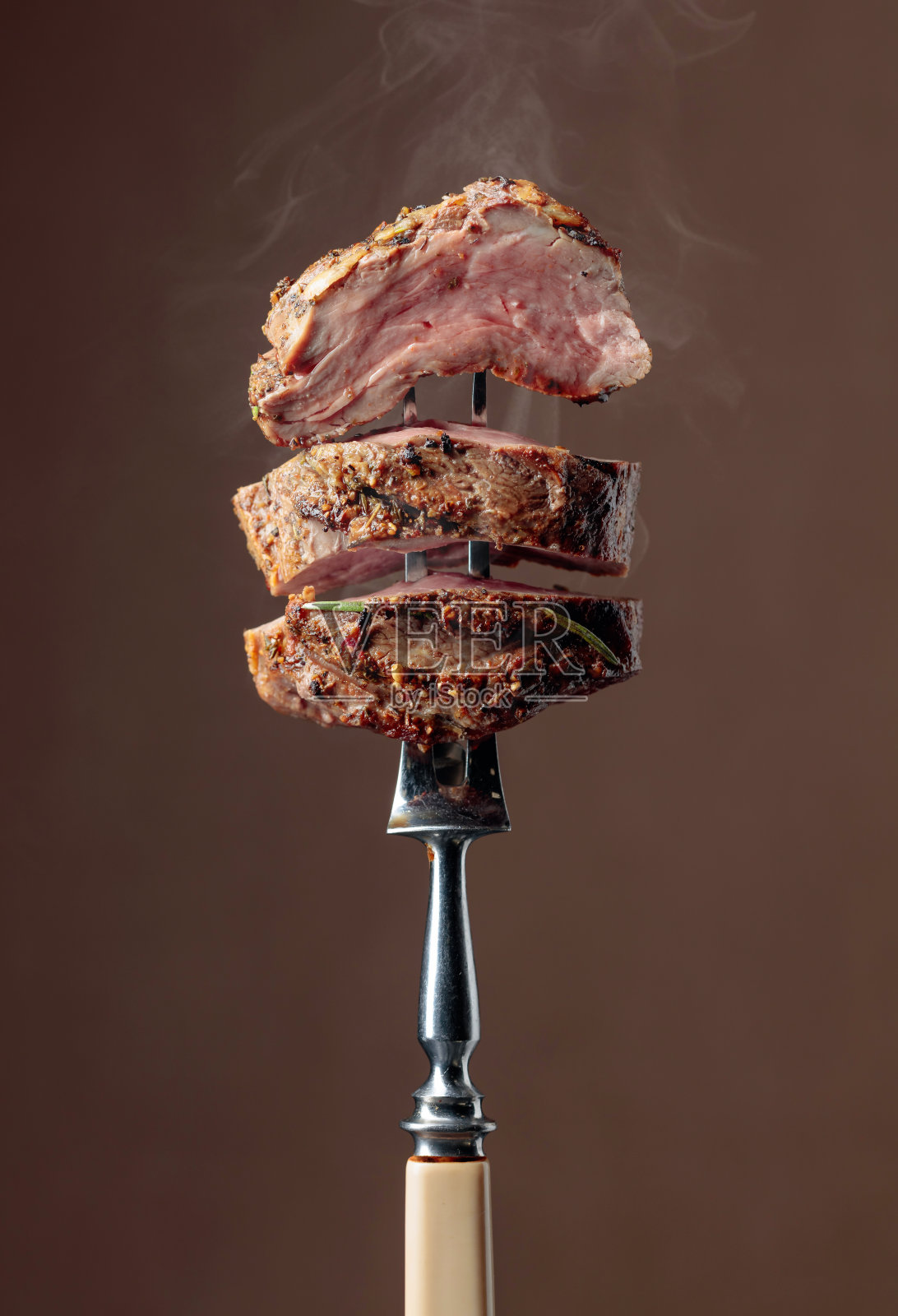 烤肋眼牛排与迷迭香在棕色的背景。照片摄影图片