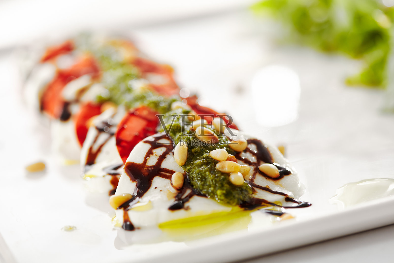 美食,餐厅,美味的晚餐食物-近距离卡普里沙拉。番茄,马苏里拉芝士,意大利香醋沙拉。沙拉酱配香蒜沙司和芝麻菜沙拉照片摄影图片