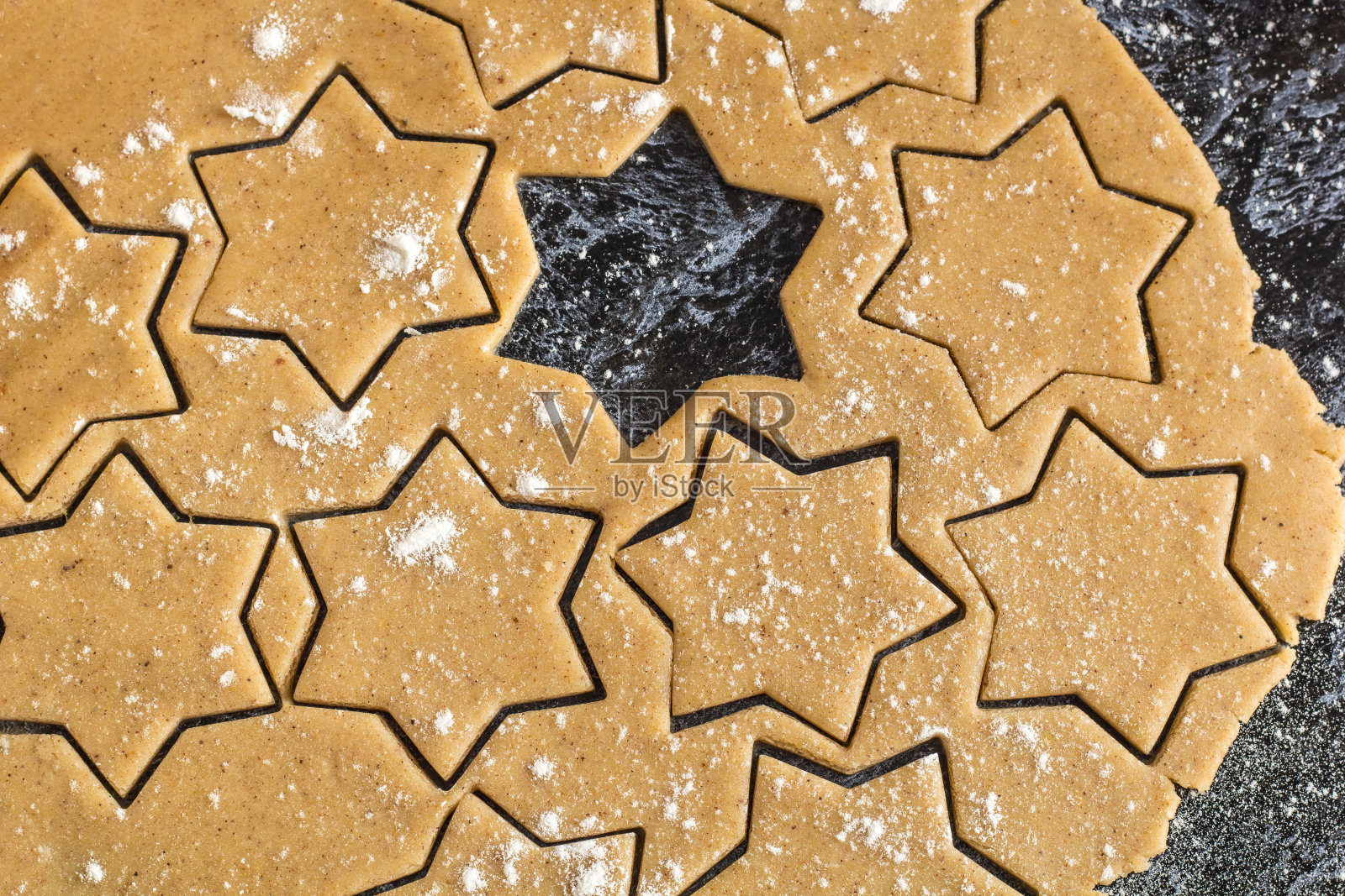 生的圣诞节自制姜饼面团在黑色的桌子上铺开照片摄影图片